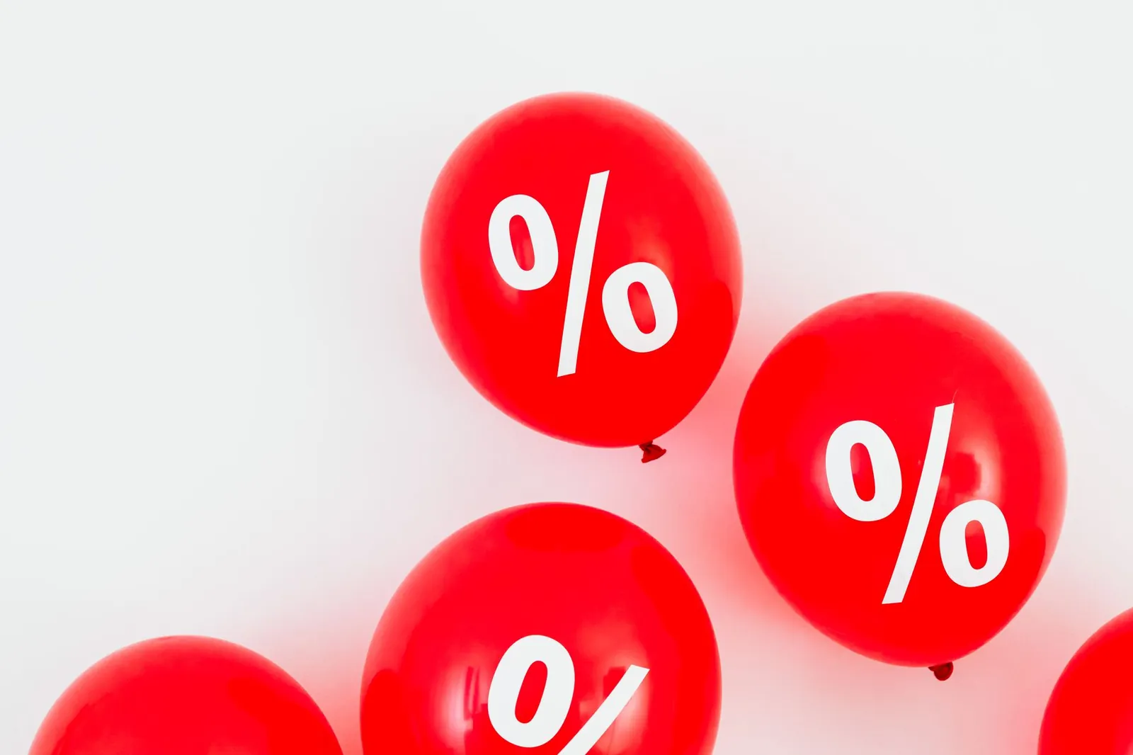 Bright red balloons with percent symbols, ideal for sales promotions and discounts. Stock photo for the ALFA News guide: What Promoter Share Selling Means for Investors.
