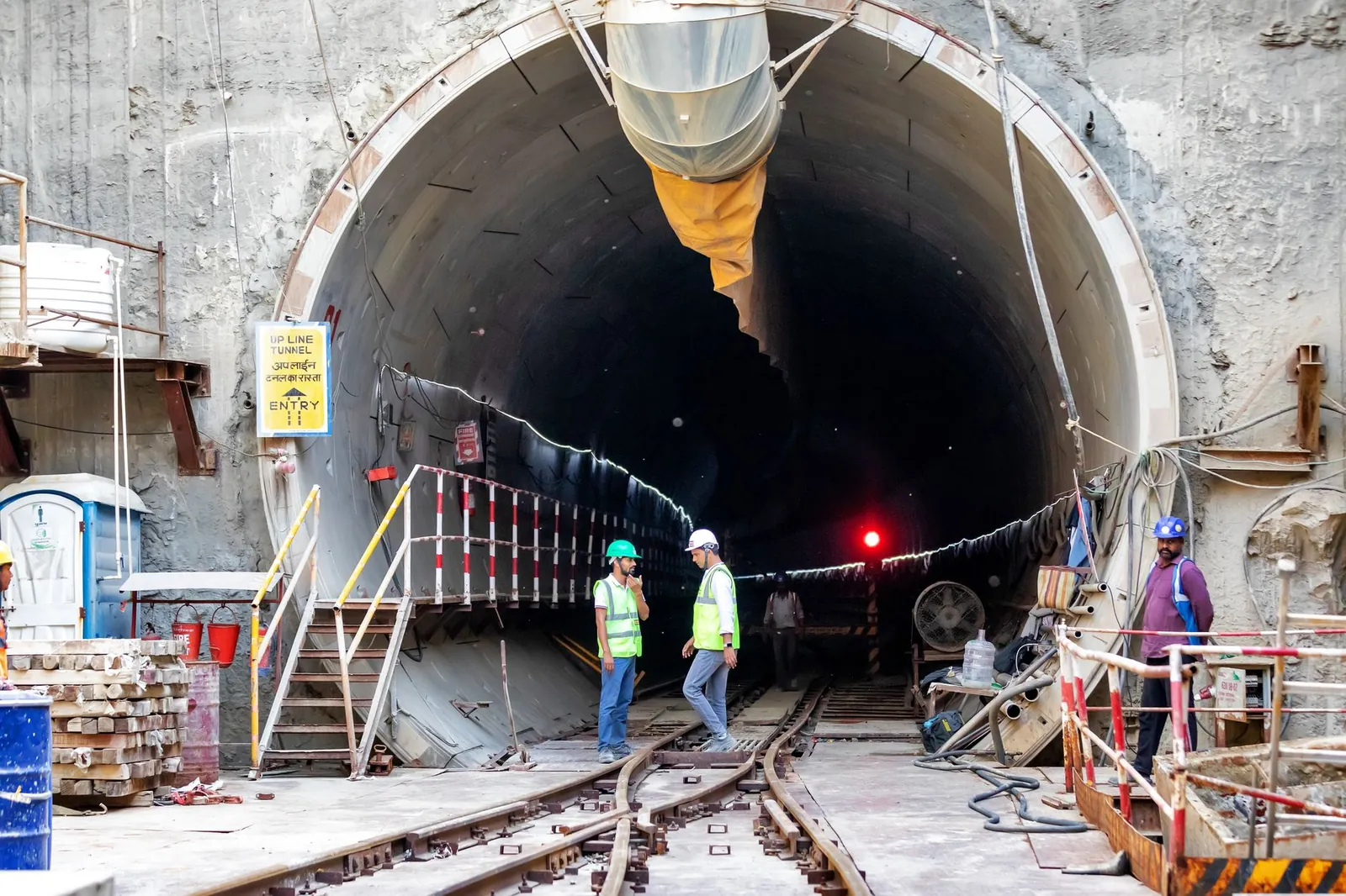 Construction workers in a tunnel. Workers in safety gear stand by a tunnel entrance. Stock photo illustrating Univastu India's new order story.