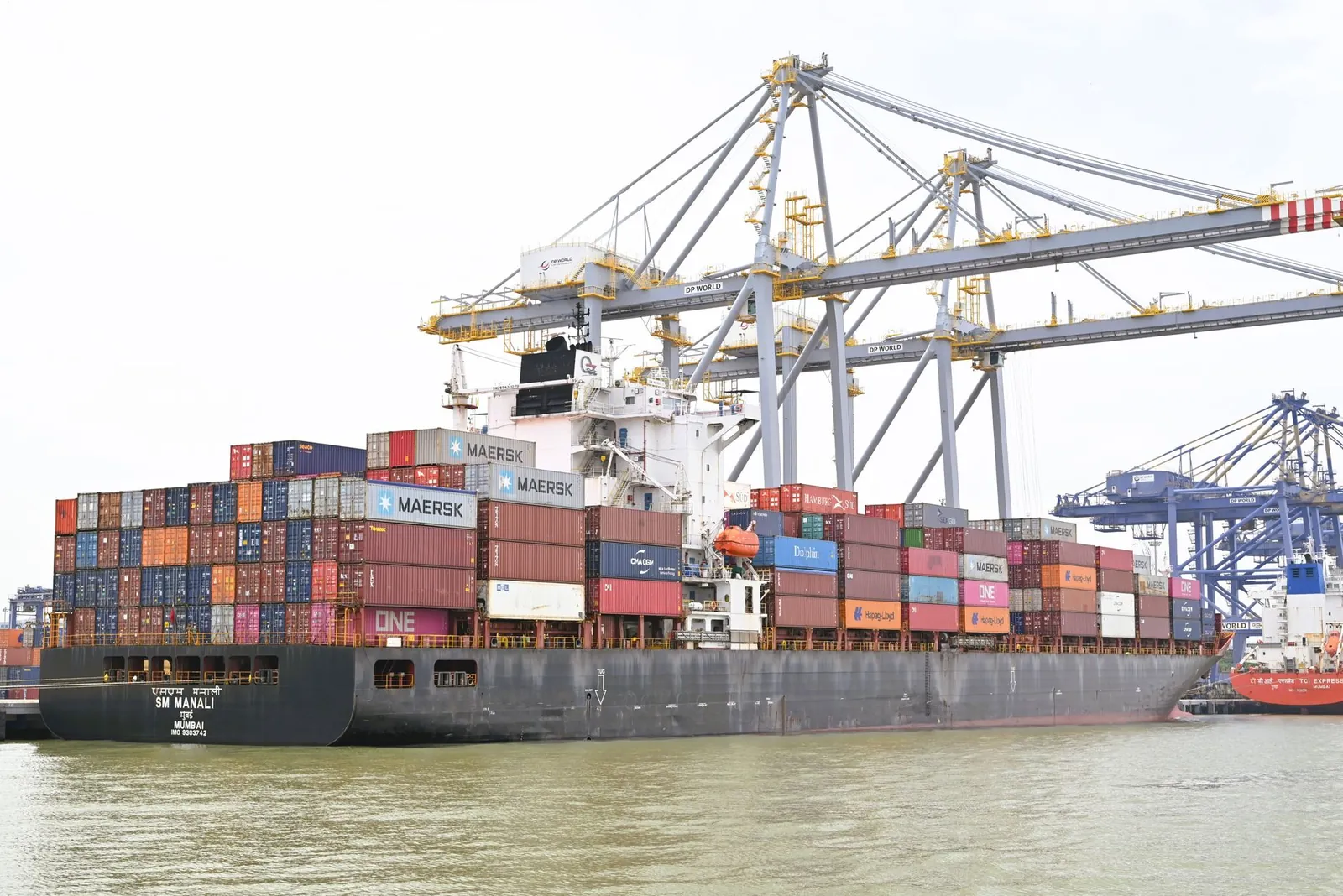 Cargo vessel moored at Kochi, Kerala, India, showcasing global container shipping with cranes in background. Stock photo illustrating Kalyani Cast-Tech's regulatory approval story.