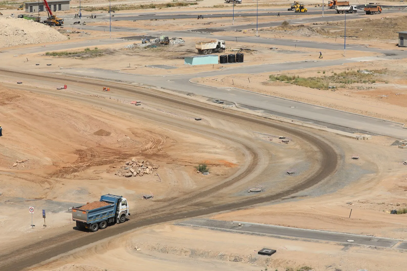 Drone shot of a developing construction site in Konza, Machakos County with dump trucks and dirt roads. Stock photo illustrating H.G. Infra Engineering's production started story.