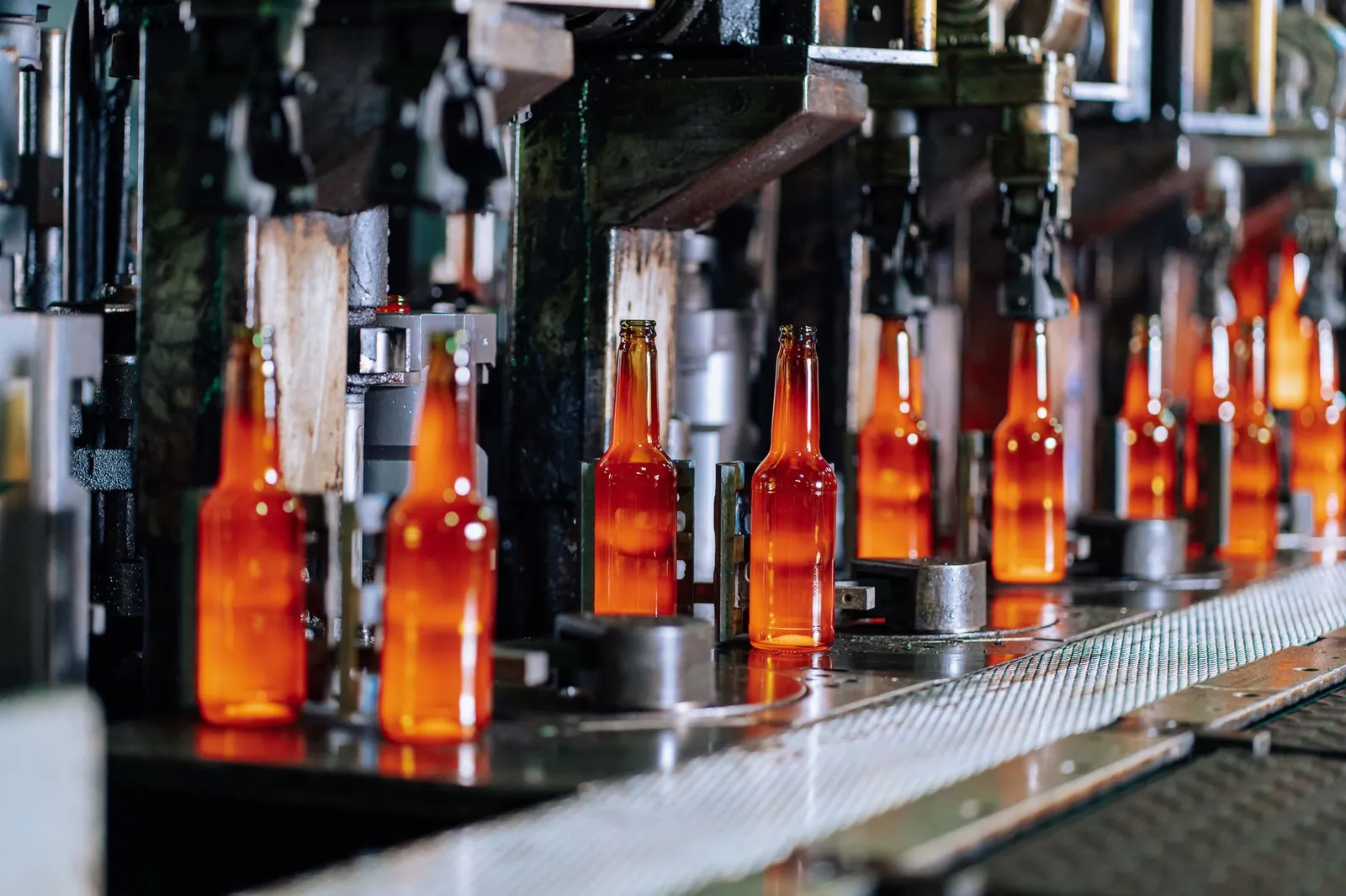 Glass bottles on a production line in a modern glass factory, showcasing industrial automation. Stock photo illustrating Sejal Glass' earning call story.