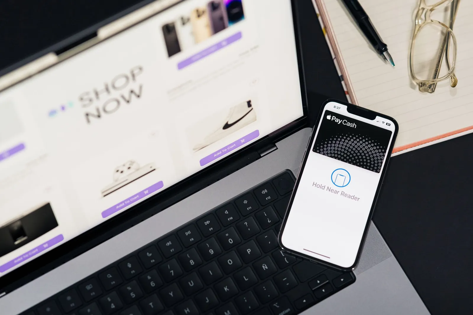 Laptop and smartphone showcasing online shopping and mobile payment setup on desk. Stock photo illustrating OnEMI Technology Solutions' fund raise story.