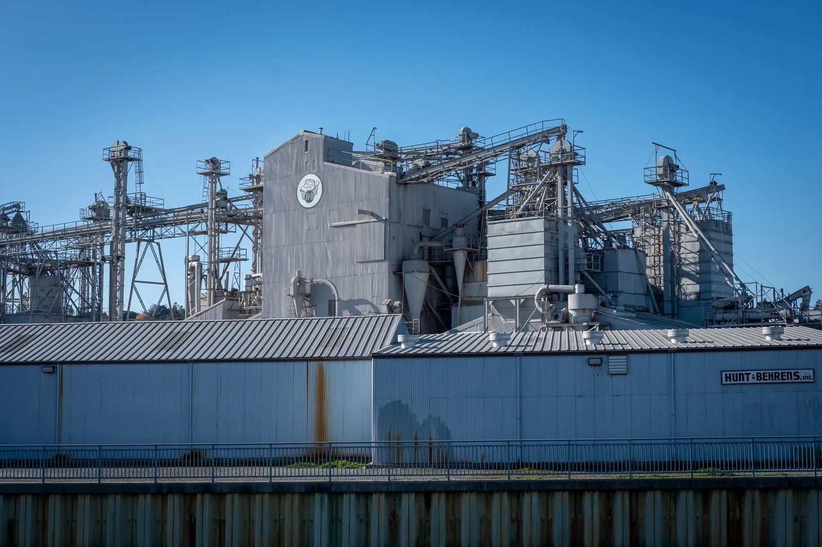 A large industrial facility showcasing metal structures and machinery under a clear blue sky. Stock photo illustrating CFF Fluid Control's new order story.