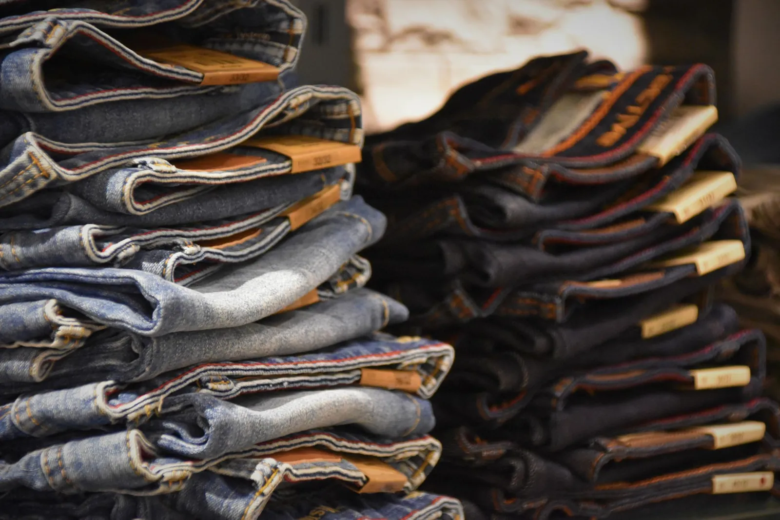 Close-up of folded denim jeans stacked in a retail store setting. Stock photo illustrating Kewal Kiran Clothing's earning call story.