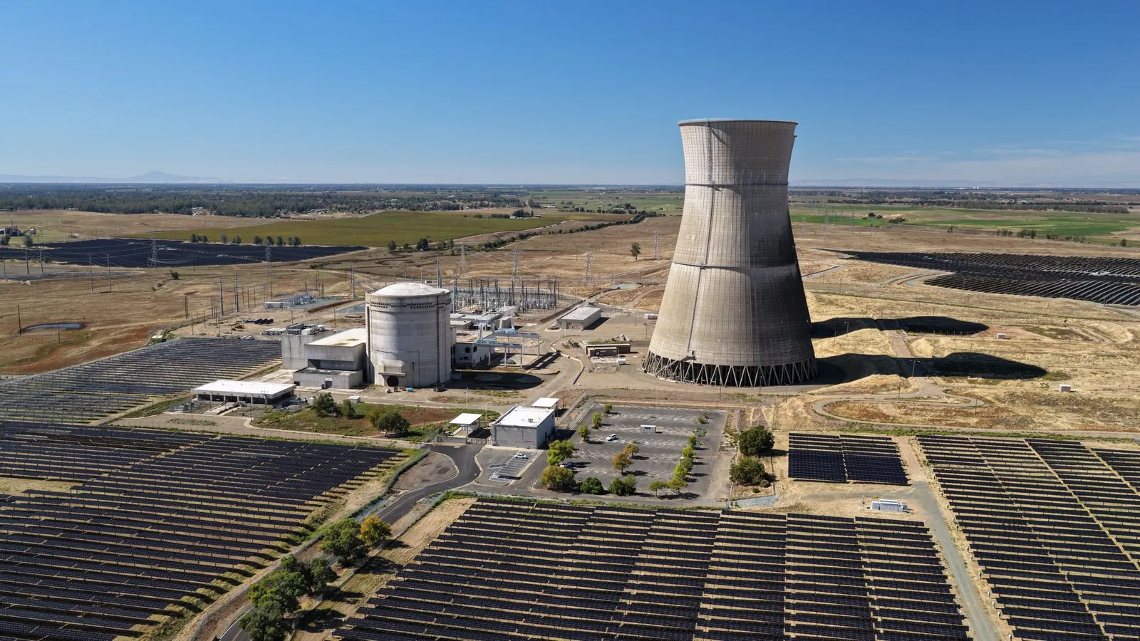 Aerial shot of Rancho Seco Solar Power Plant with large cooling tower and solar panels. Stock photo illustrating Suratwwala Business Group's new order story.