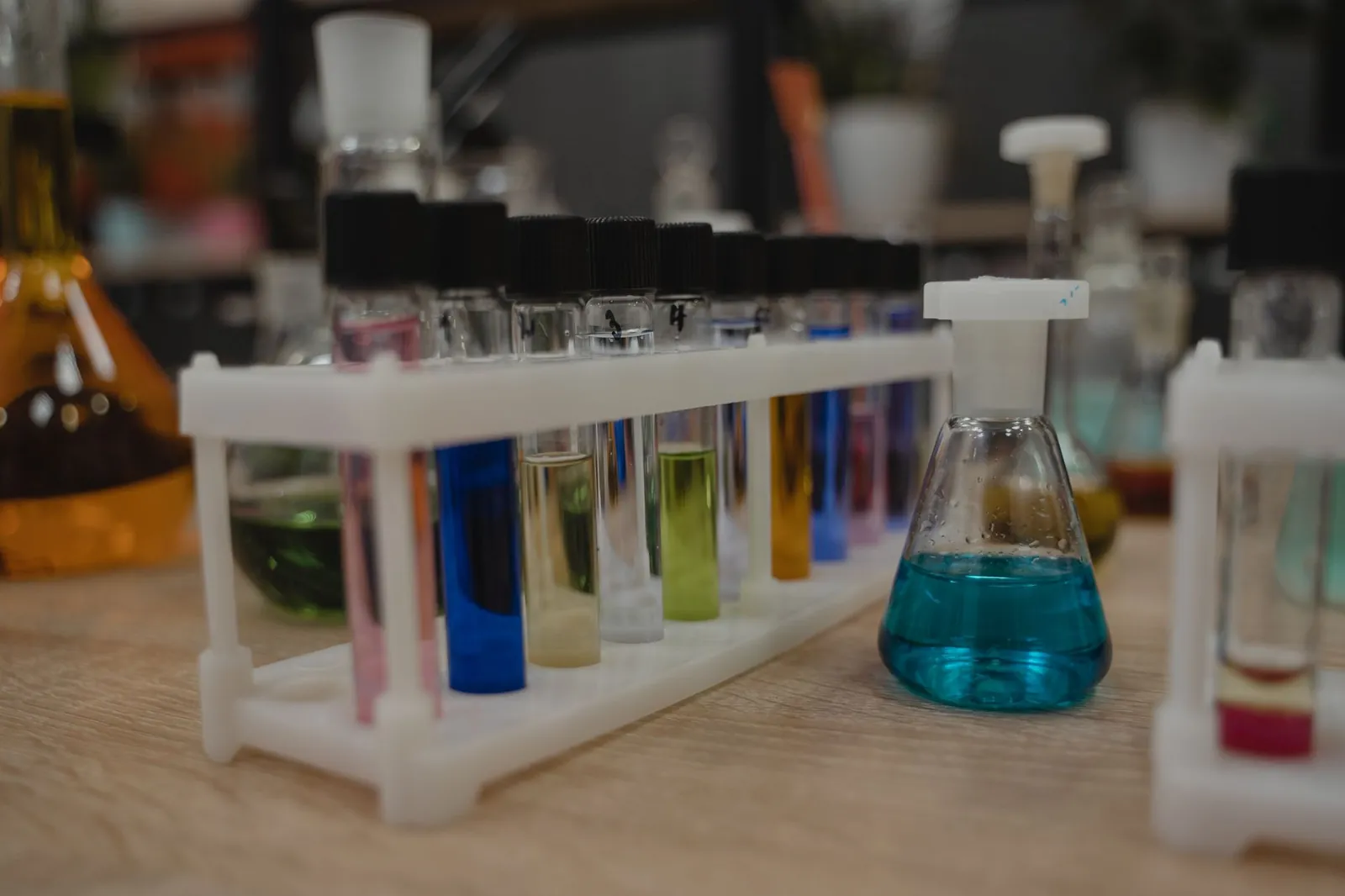 A collection of colorful test tubes and flasks in a chemistry laboratory setting. Stock photo illustrating Privi Speciality Chemicals' regulatory approval story.