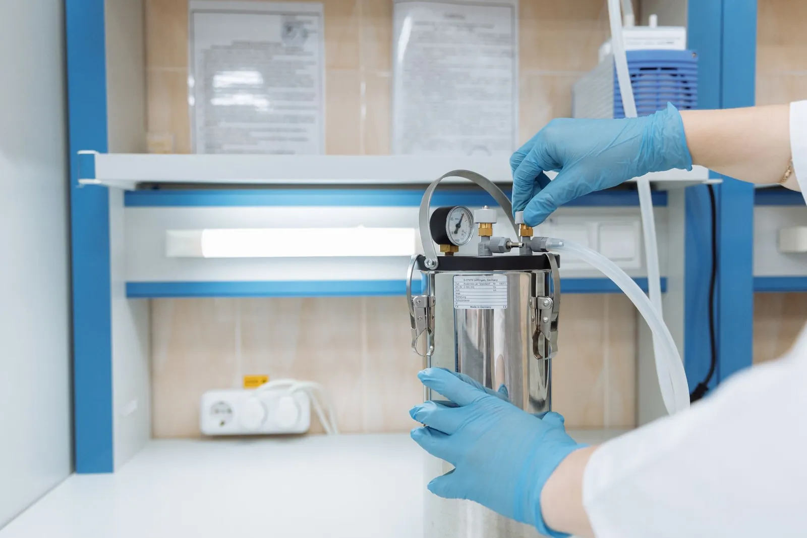 Scientist adjusting laboratory equipment with precision in a modern lab setting, wearing blue gloves. Stock photo illustrating Alivus Life Sciences' financial results story.