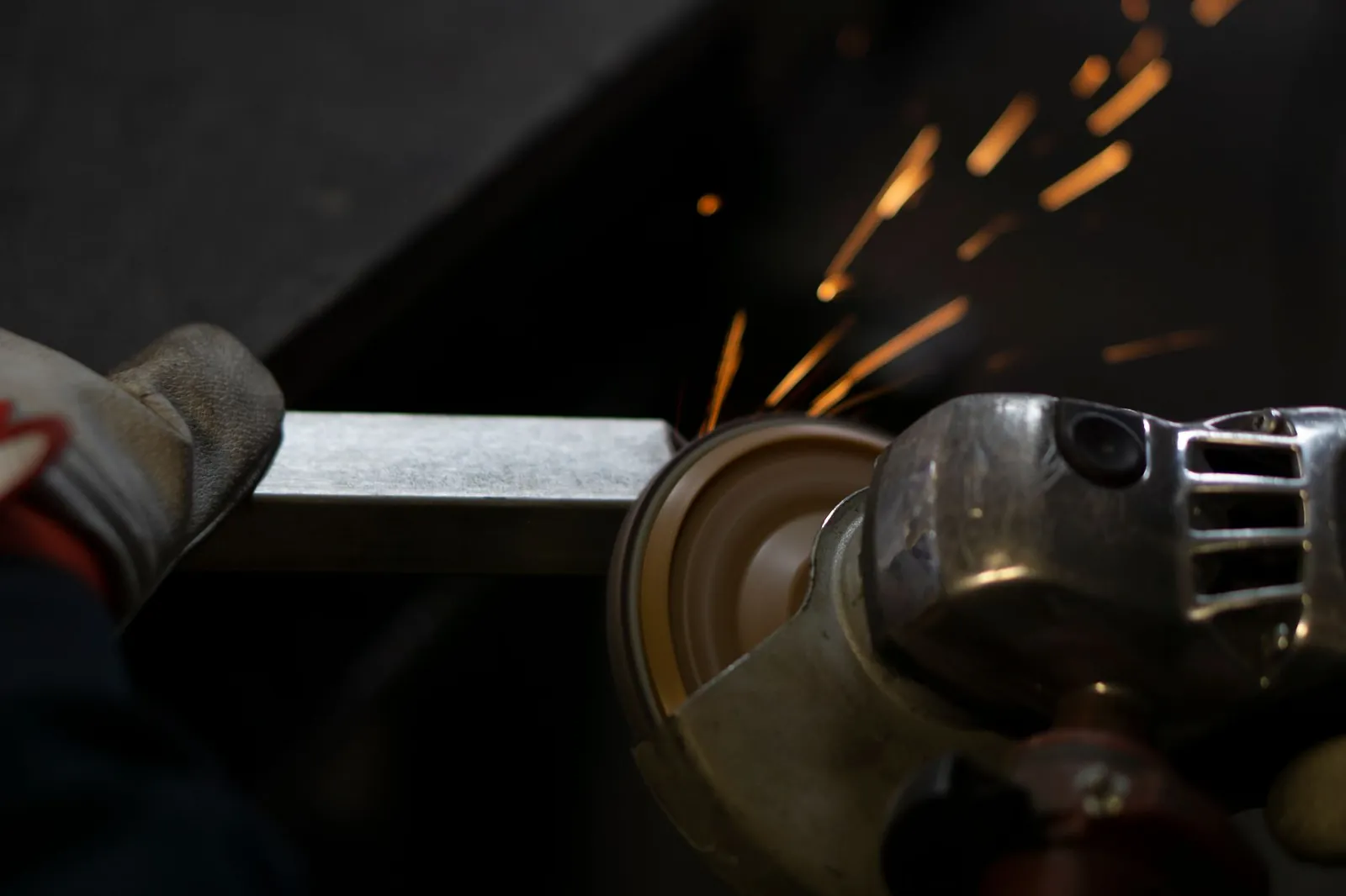 Angle grinder working on steel, emitting bright sparks. Industrial close-up shot. Stock photo illustrating Axtel Industries' partnership story.