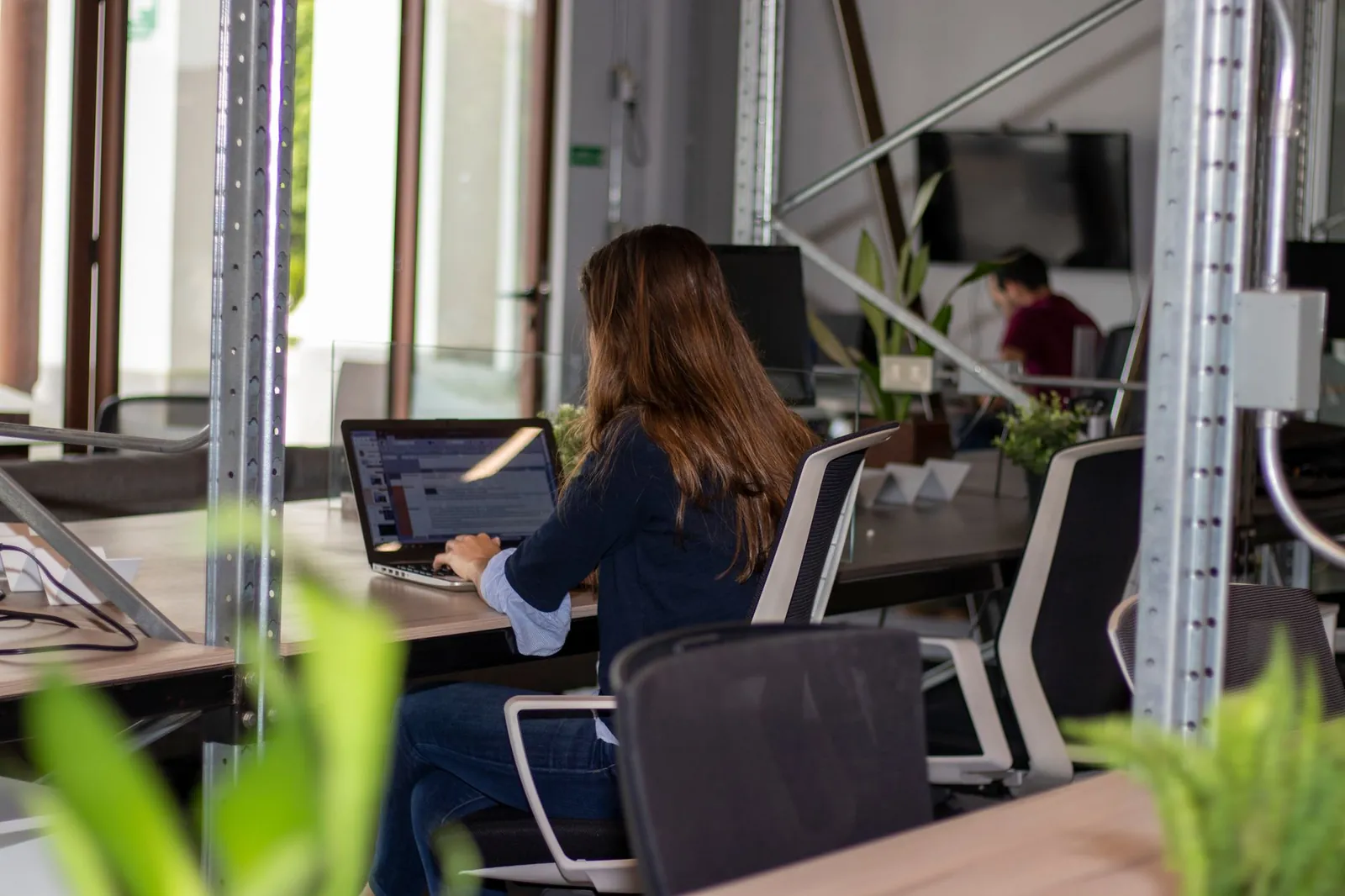 Woman working on a laptop in a stylish coworking office space. Stock photo illustrating Smartworks Coworking Spaces' new order story.