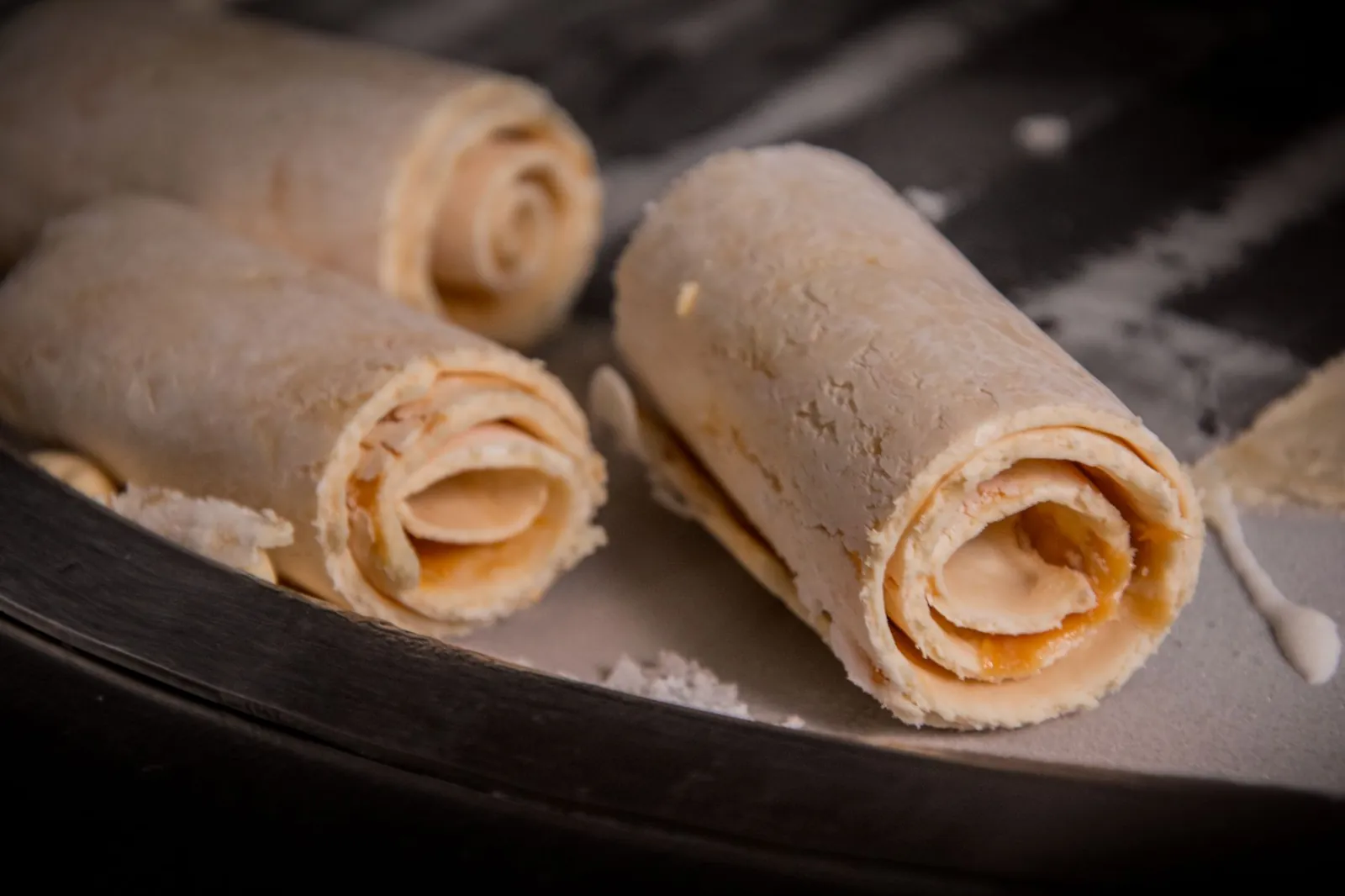 Close-up view of rolled ice cream being prepared with focus on the texture and swirls. Stock photo illustrating Krishival Foods' earning call story.