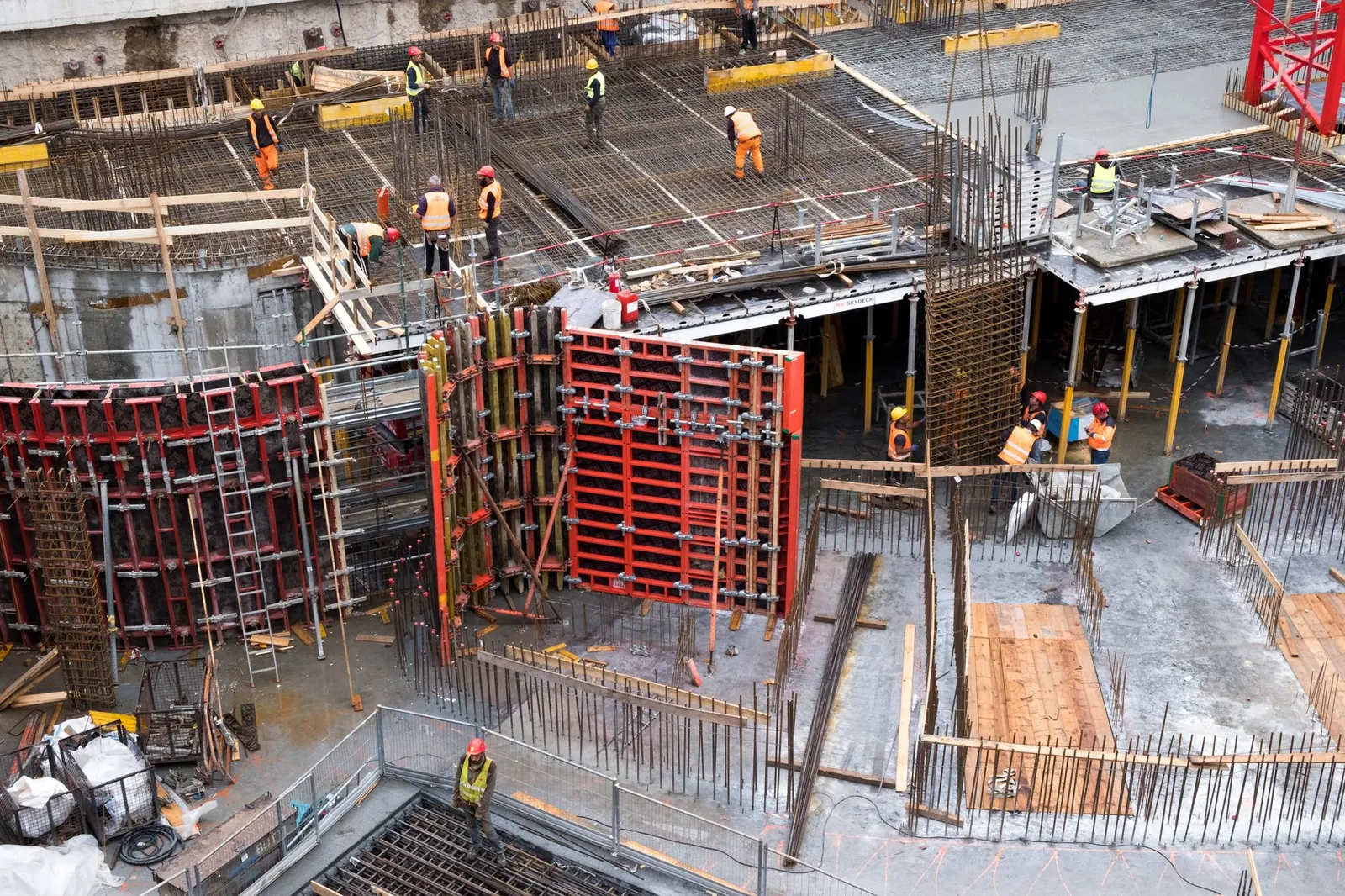 Industrial construction site with workers in high visibility clothing at a steel framework structure. Stock photo illustrating Power Mech Projects' new order story.