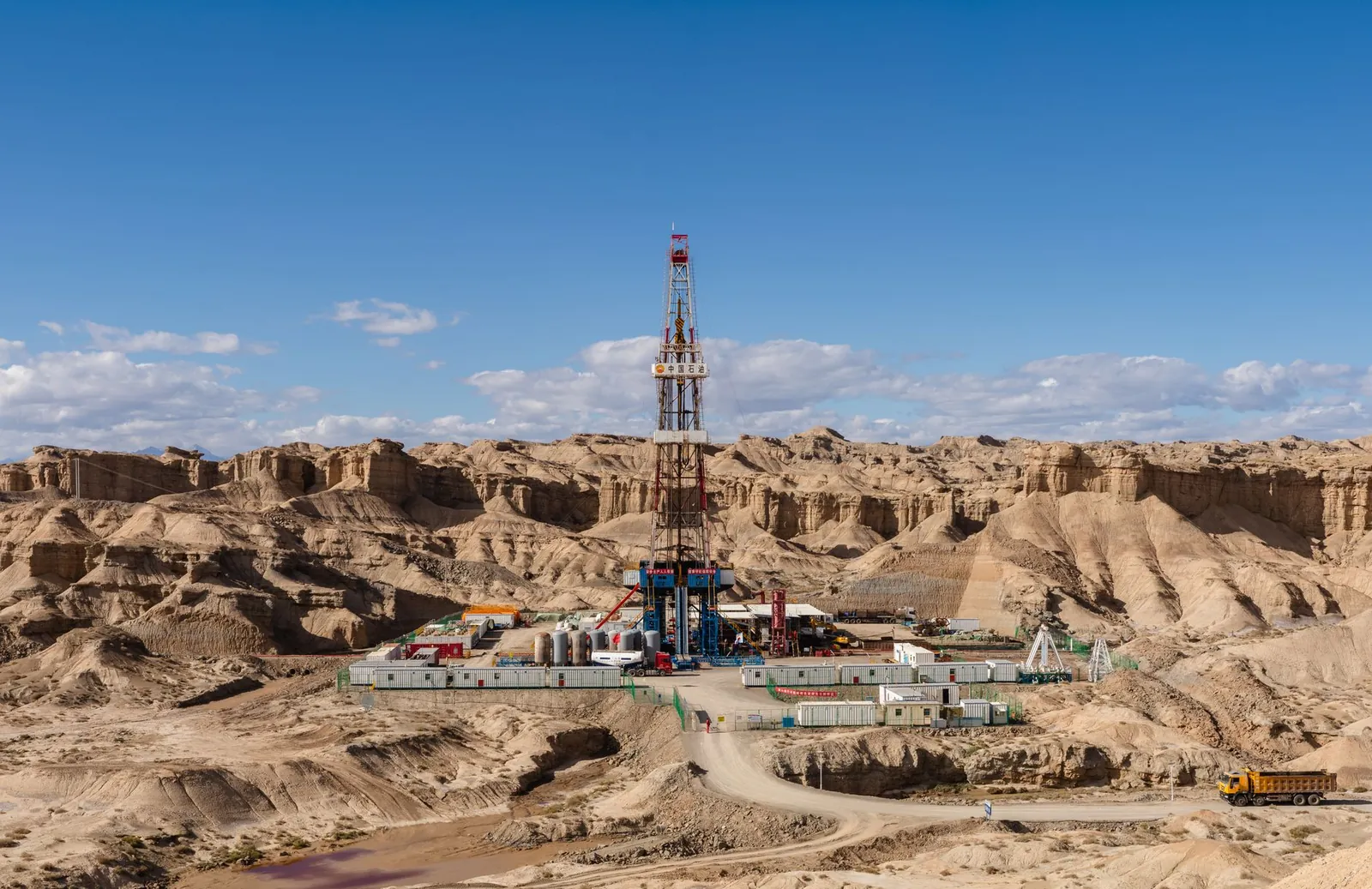 Aerial view of an oil rig amidst desert rock formations, showcasing industrial exploration. Stock photo illustrating Asian Energy Services' financial results story.