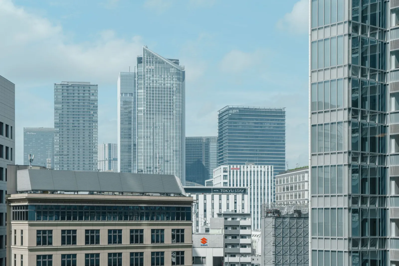Cityscape featuring glass skyscrapers under a clear blue sky, ideal for urban themes. Stock photo illustrating Mphasis' expansion story.