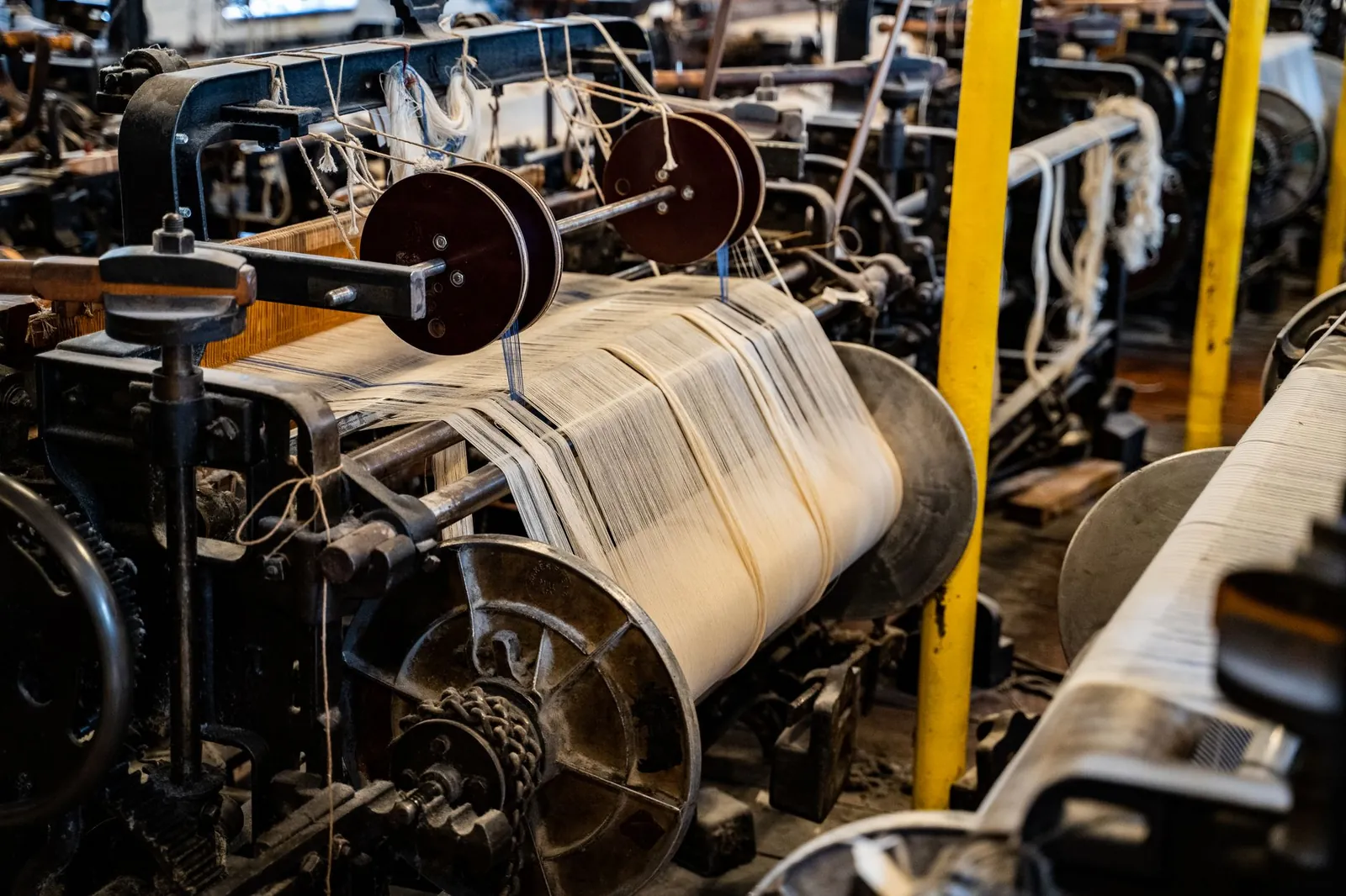 Detailed view of a vintage textile machine showcasing industrial sewing equipment. Stock photo illustrating Swaraj Suiting's fund raise story.