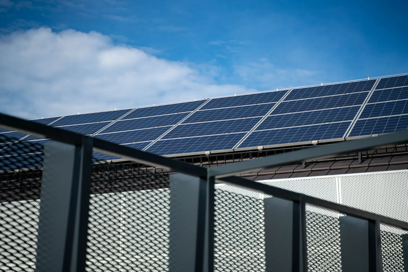 Close-up view of modern solar panels on a rooftop against a clear blue sky, representing clean energy. Stock photo illustrating Oswal Pumps' new order story.