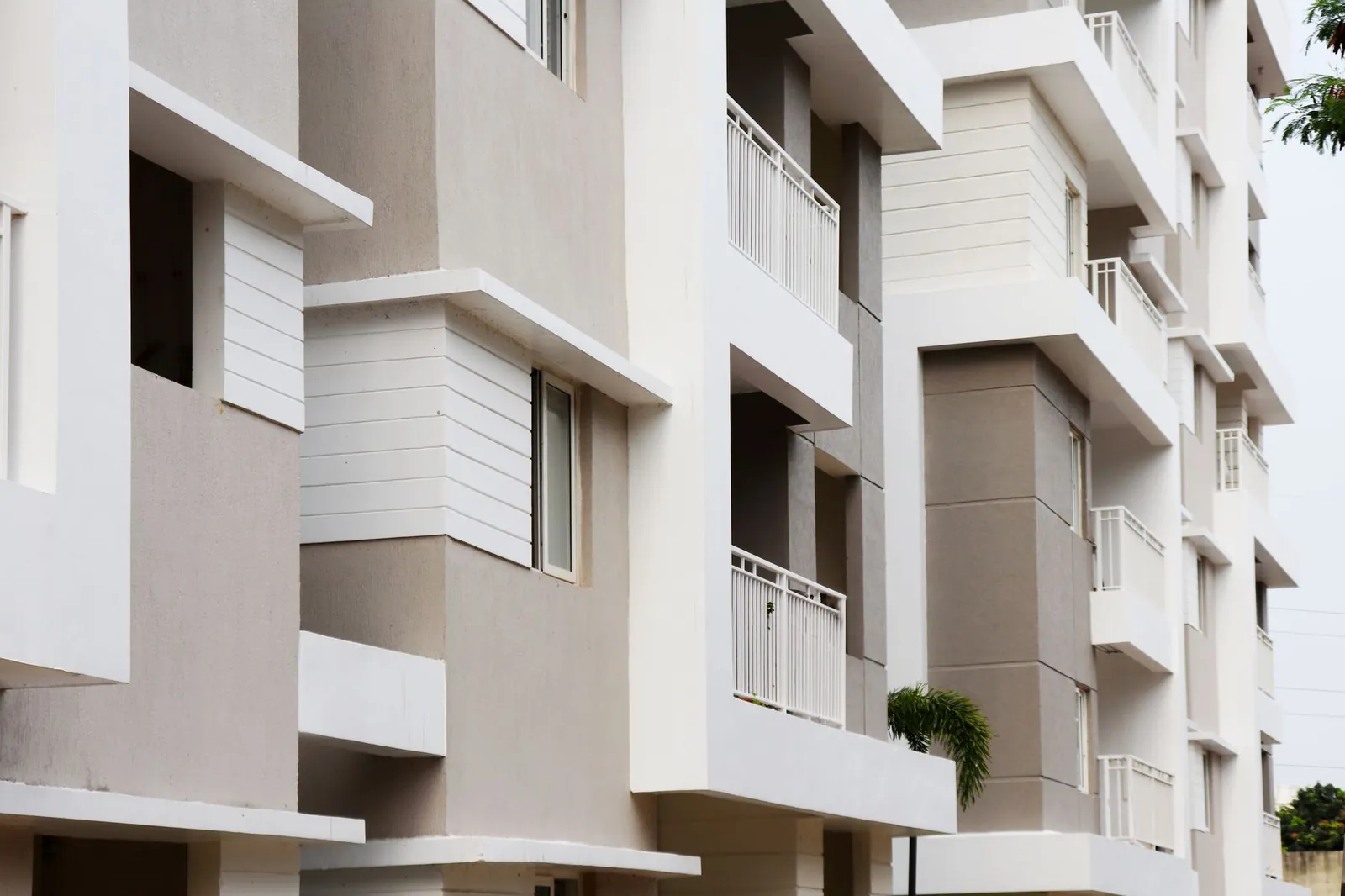 A modern apartment building exterior with balconies in Hyderabad, India. Stock photo illustrating Modis Navnirman's earning call story.