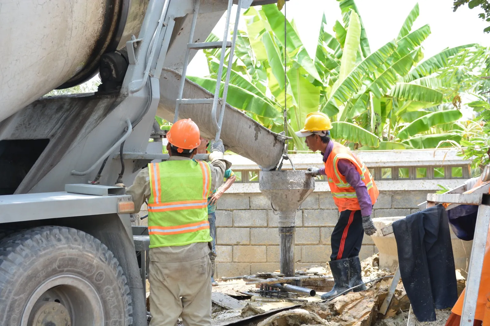 Construction team pouring concrete on site with mixer truck, enhancing a sturdy foundation. Stock photo illustrating Organic Recycling Systems' new order story.