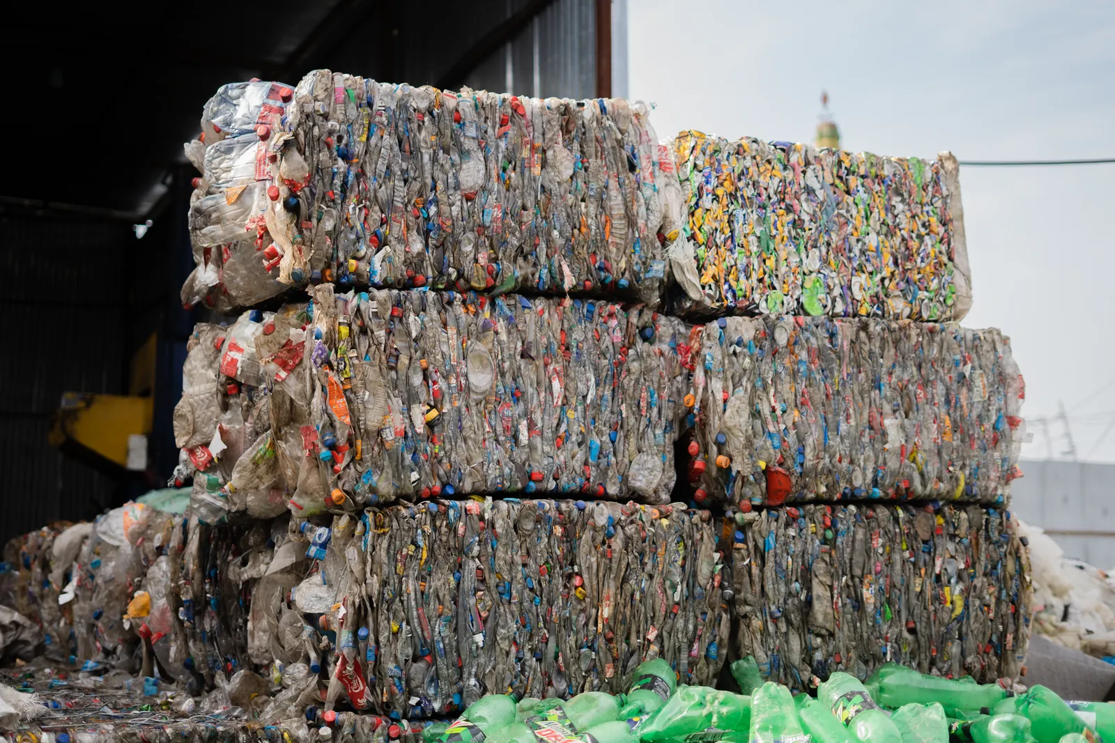 Stacked compressed plastic bottles at a recycling facility, ready for processing. Stock photo illustrating Organic Recycling Systems' fund raise story.