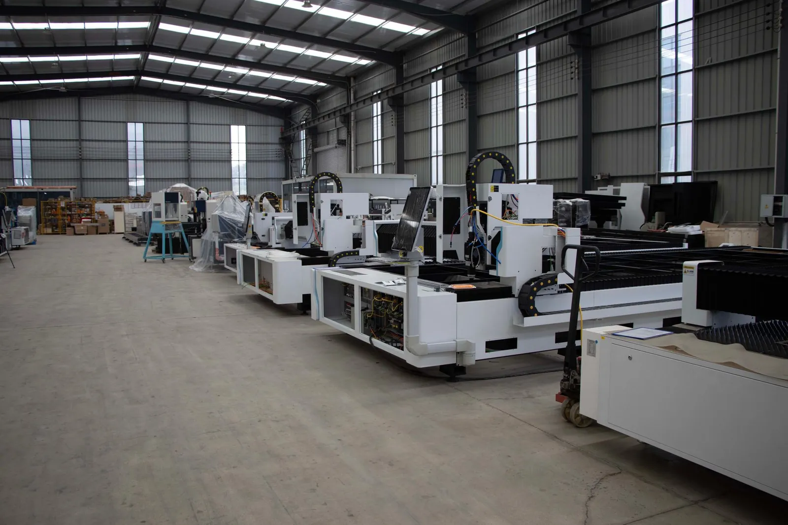 Row of advanced industrial manufacturing machines inside a spacious warehouse setting. Stock photo illustrating Diamond Power Infrastructure's production started story.