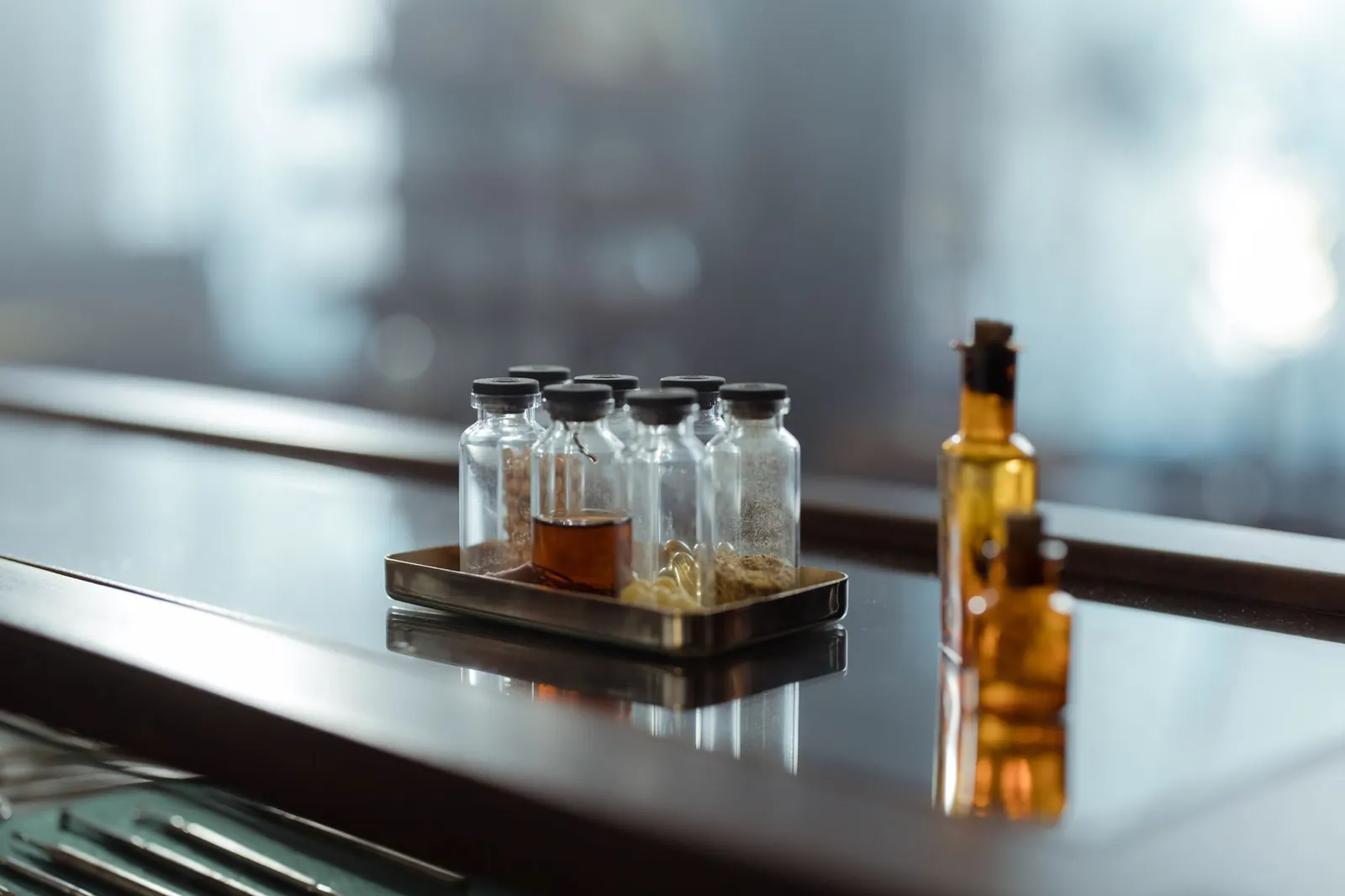 A captivating arrangement of medicine bottles on a reflective surface, evoking a sense of chemistry and alchemy. Stock photo illustrating Sai Parenterals' new order story.