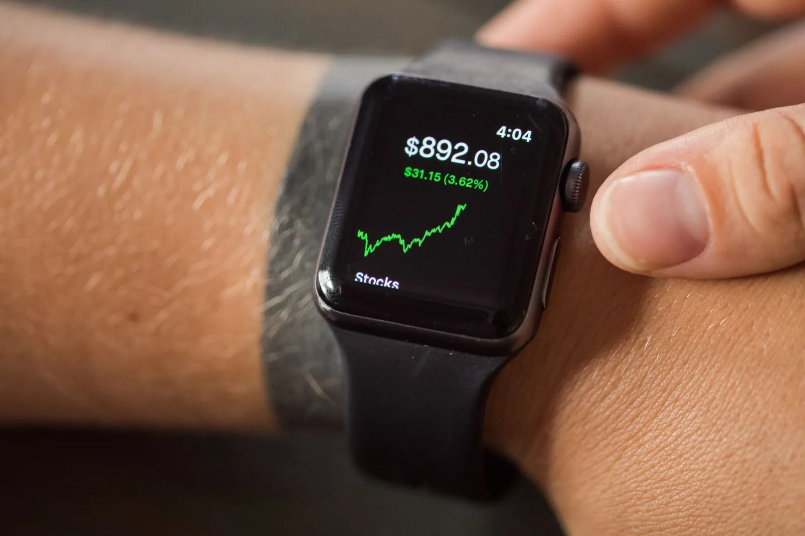 Close-up of a smartwatch showing stock market trends and financial data. Stock photo for the ALFA News guide: How to Choose a Stock Market Notification App.