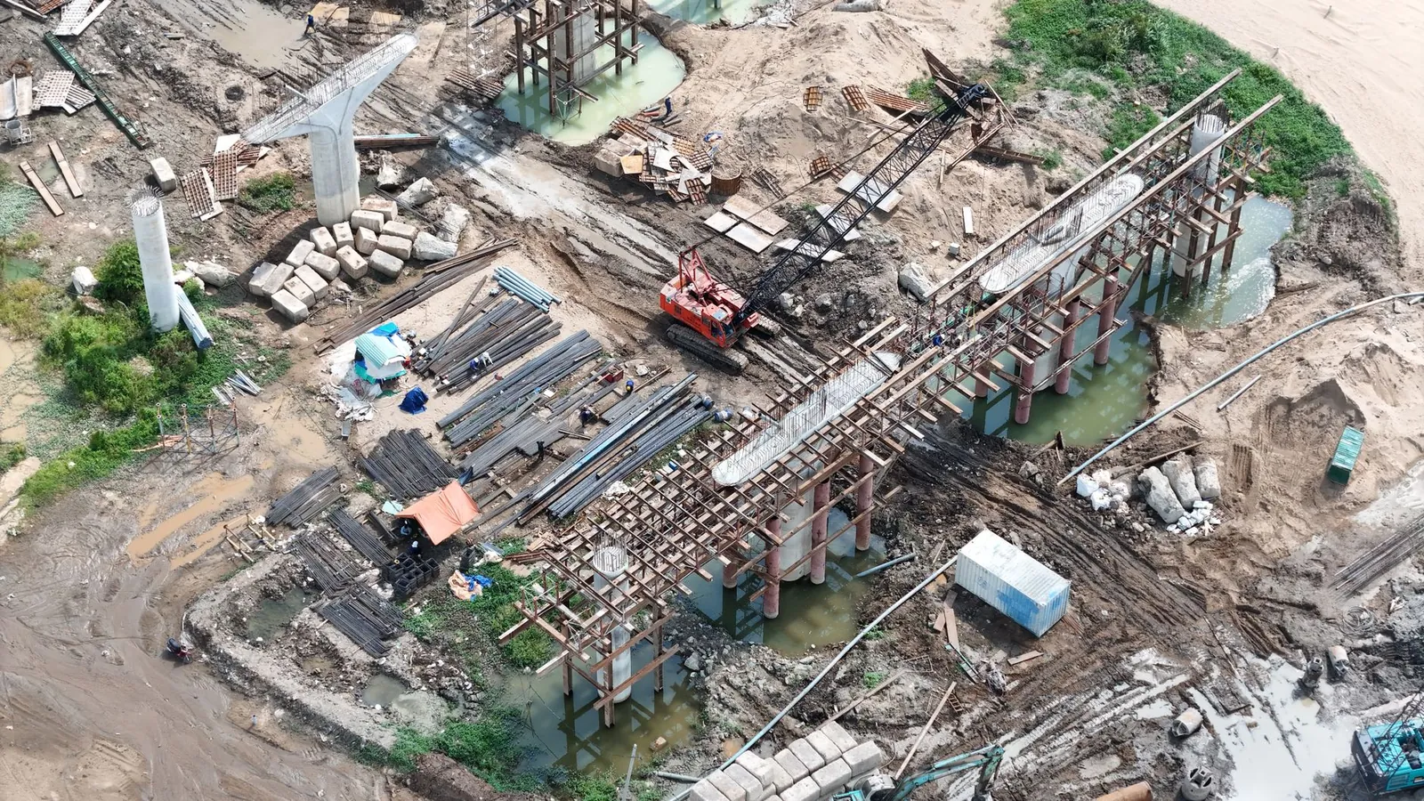 Aerial shot showcasing bridge construction with cranes and materials on site. Stock photo illustrating Brahmaputra Infrastructure's earning call story.