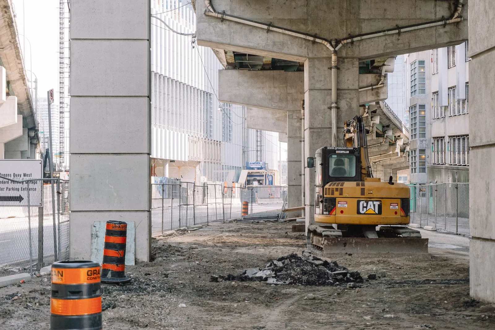 Site of roadway under concrete bridge construction with heavy equipment on dirty ground. Stock photo illustrating Highway Infrastructure's earning call story.