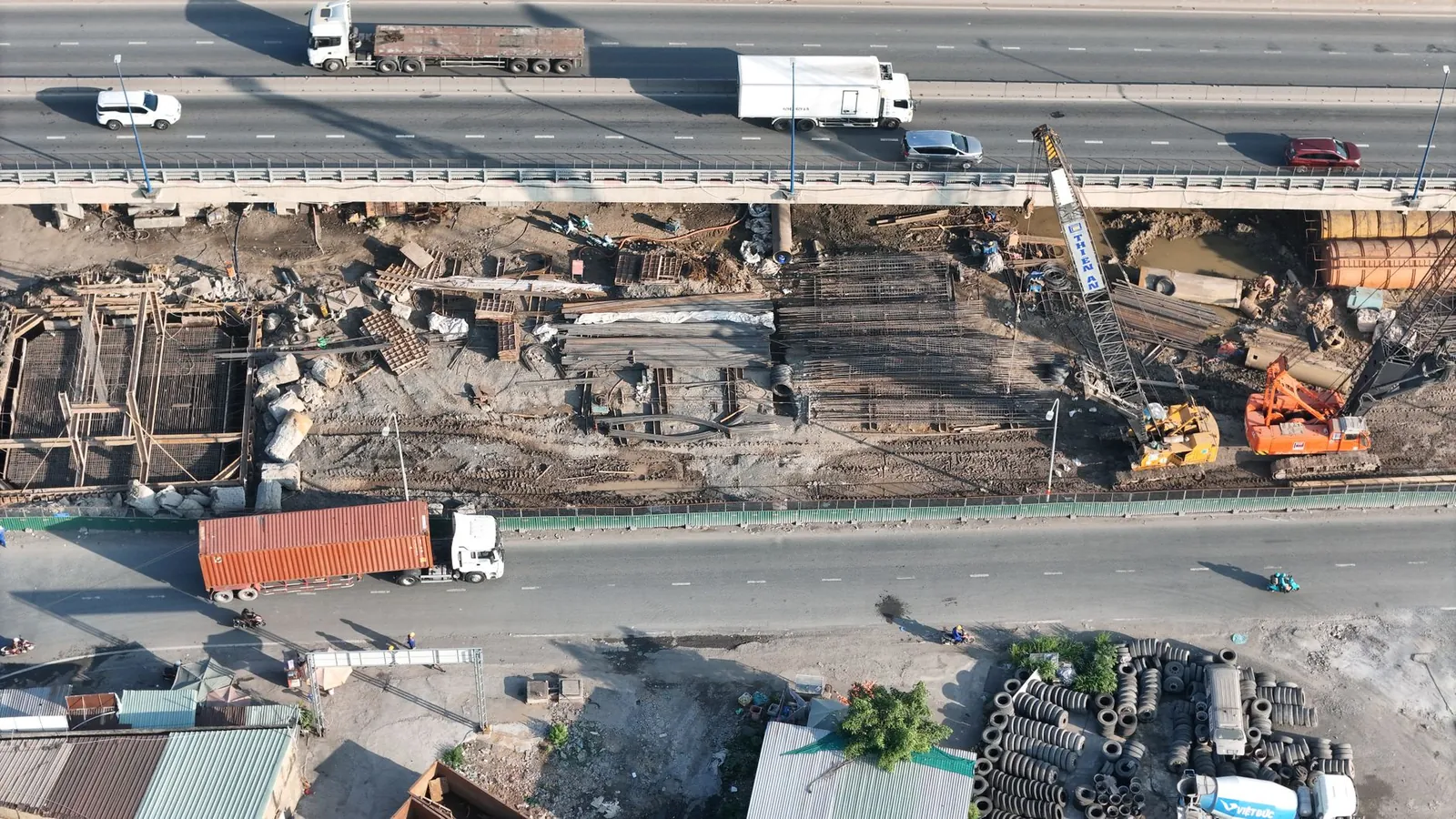 Aerial shot of a bridge construction site with vehicles passing on the highway above. Stock photo illustrating A B Infrabuild's new order story.