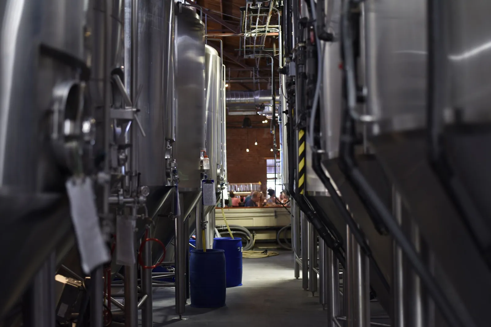 Inside view of a modern brewery with large stainless steel tanks and machinery for beer production. Stock photo illustrating Jindal Stainless' partnership story.