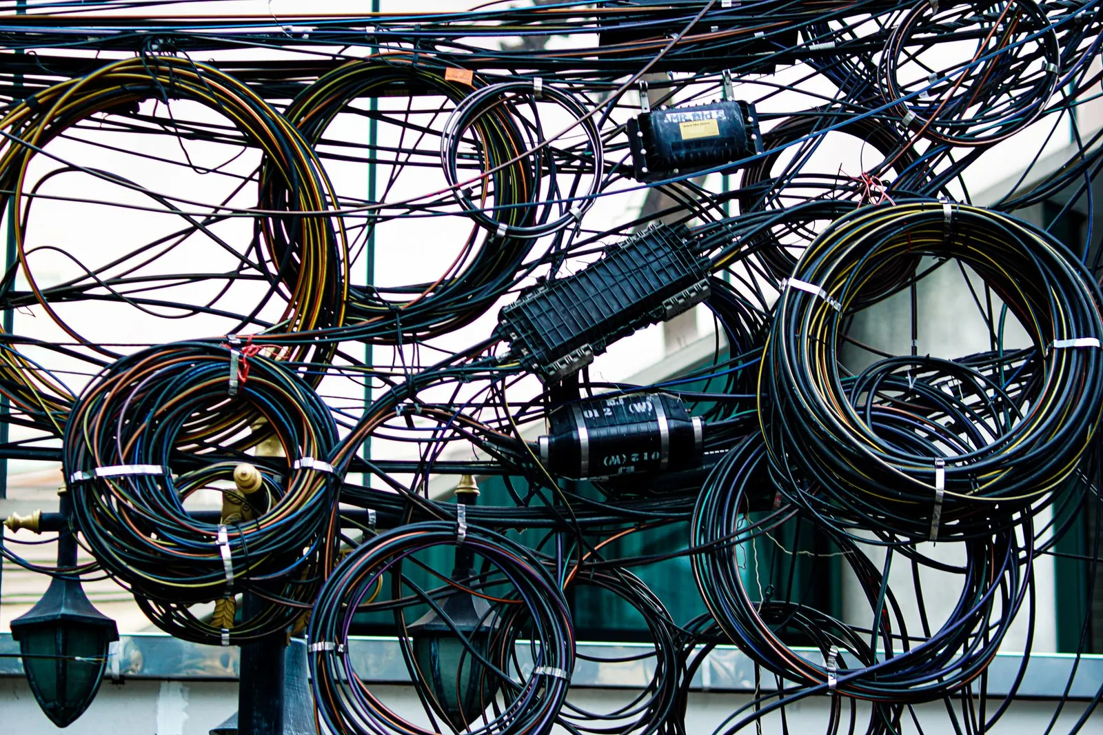 Intricate network of tangled power and communication cables outdoors. Stock photo illustrating Viviana Power Tech's new order story.