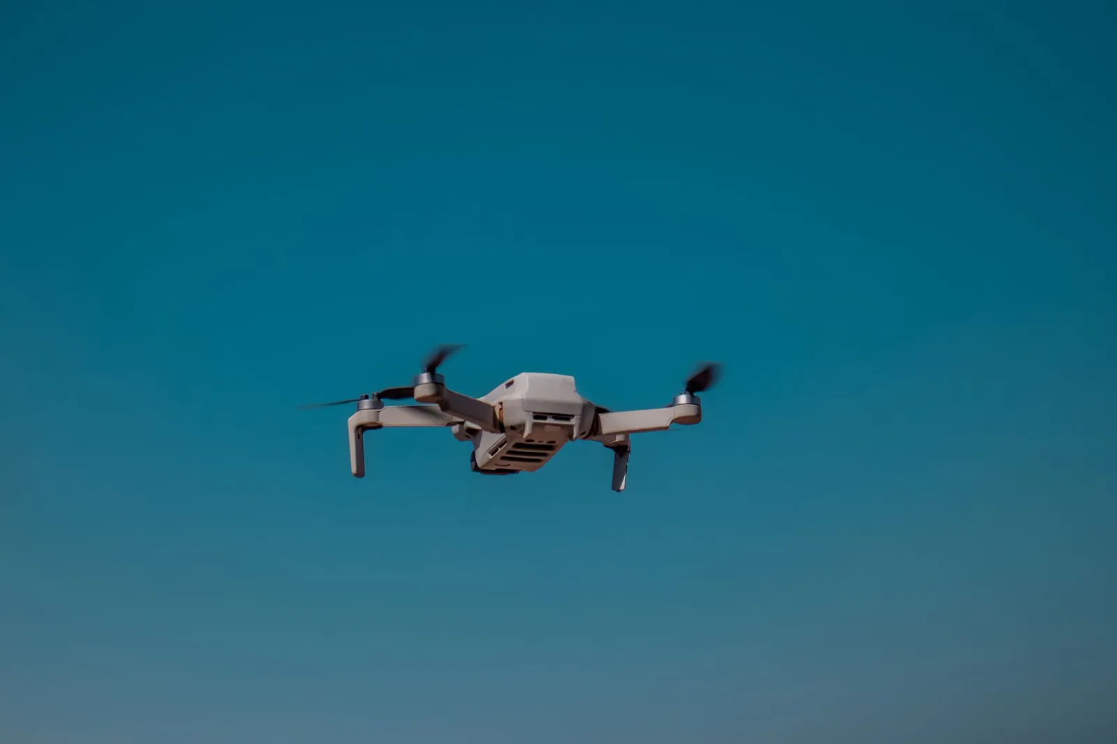 Aerial drone flying in the open sky on a clear day, showcasing modern technology. Stock photo illustrating Optivalue Tek Consulting's new order story.