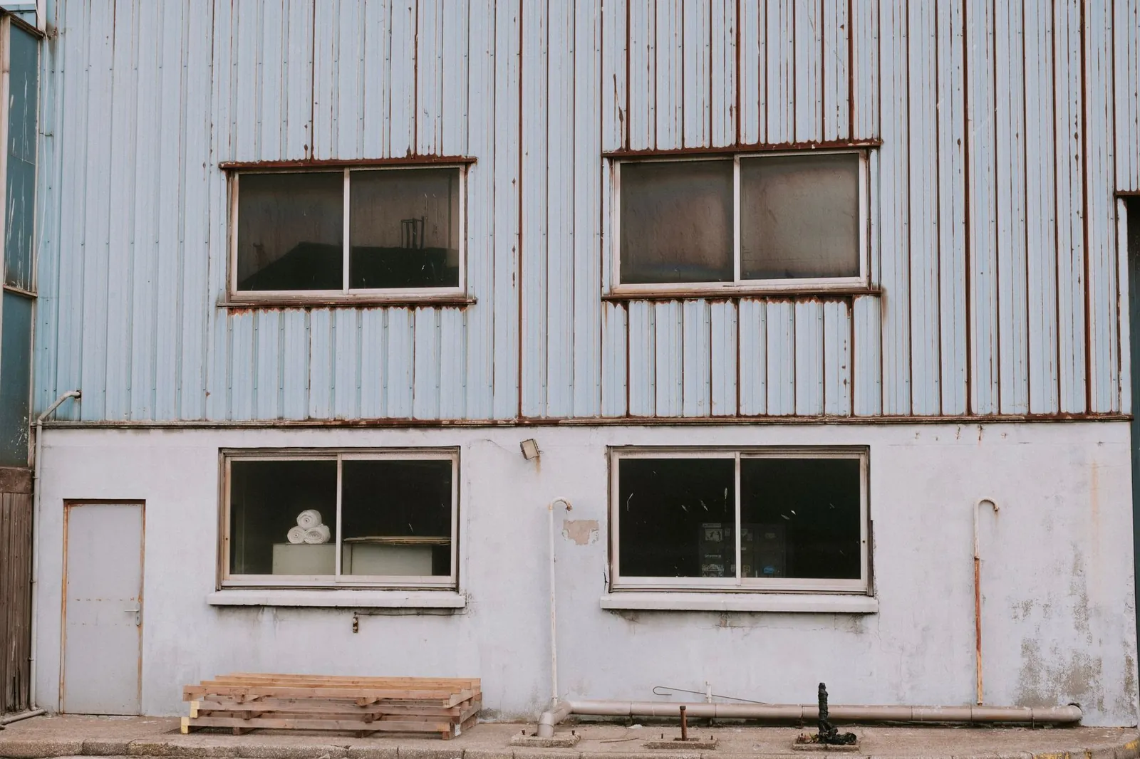 Aged industrial building exterior with windows showcasing urban decay and rustic charm. Stock photo illustrating Subros' production started story.