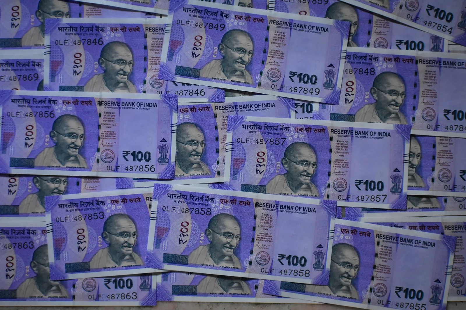 Detailed view of 100 Indian rupee notes featuring Mahatma Gandhi, symbolizing prosperity and economy. Stock photo illustrating Bank of Baroda's earning call story.