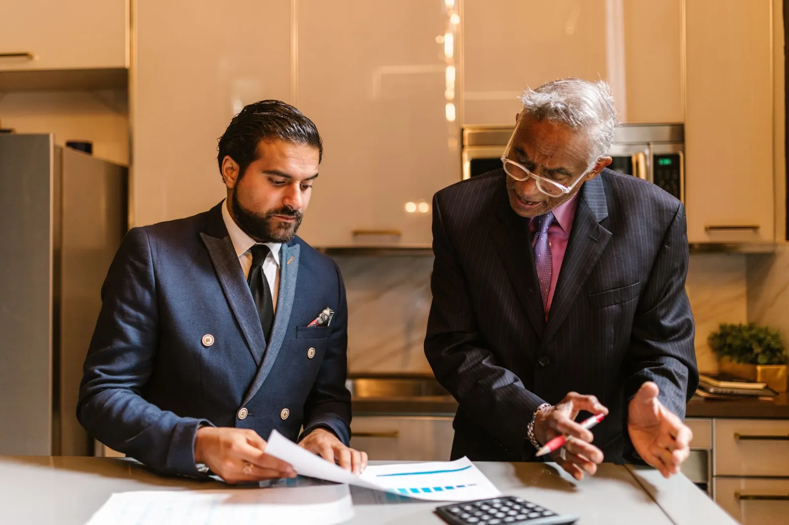 Two businessmen engaged in a focused discussion over financial documents in a modern office setting. Stock photo illustrating Regency Fincorp's earning call story.