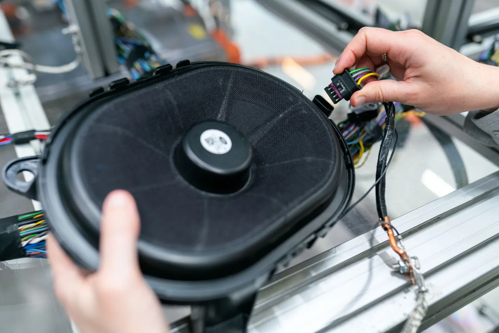 Close-up of an engineer working on a sound system speaker assembly in a workshop. Stock photo illustrating Mahindra & Mahindra's earning call story.