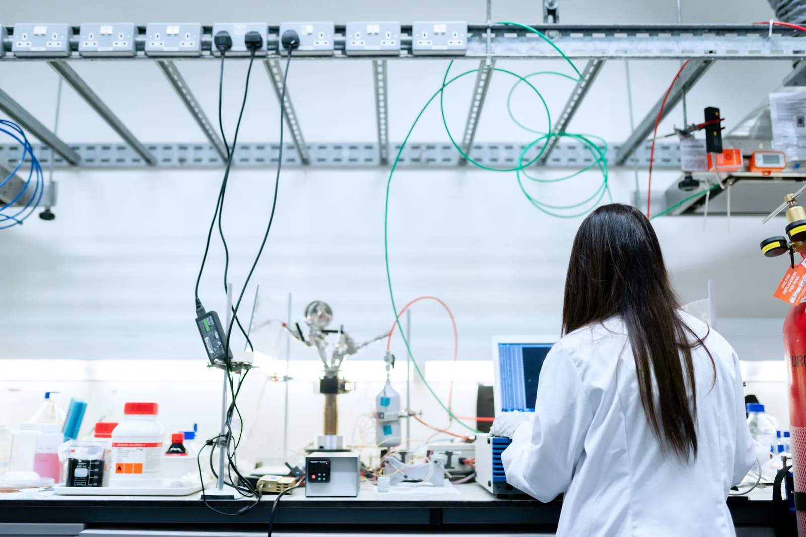 A female scientist conducting research in a contemporary laboratory full of equipment. Stock photo illustrating Blue Cloud Softech Solutions' partnership story.