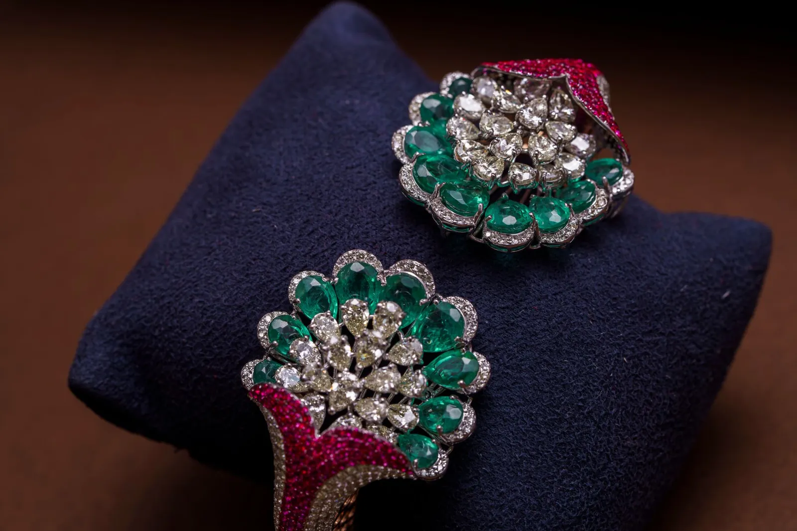 Exquisite emerald and diamond jewelry highlighting opulence on a rich dark background. Stock photo illustrating P N Gadgil Jewellers' financial results story.