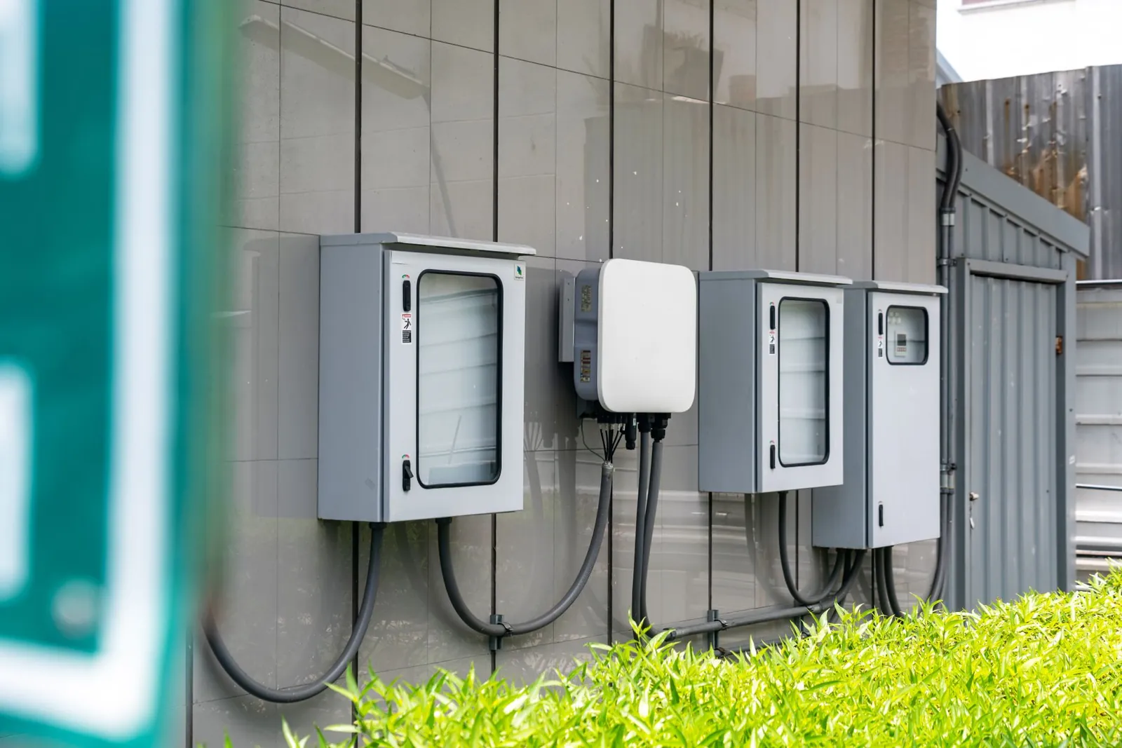 Close-up of outdoor electrical utility boxes with cabling on a building exterior. Stock photo illustrating ACME Solar Holdings' production started story.
