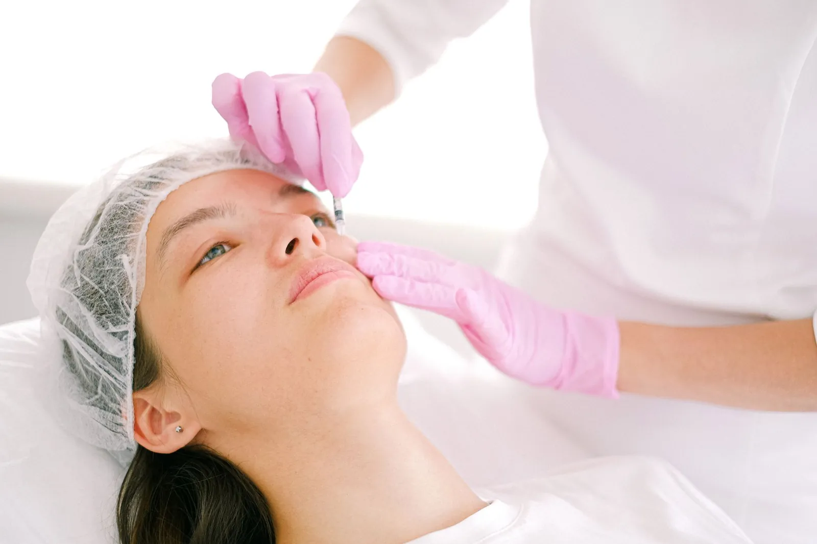 Woman receives cosmetic injection in clinical setting, enhancing beauty using modern techniques. Stock photo illustrating Biocon's product launched story.