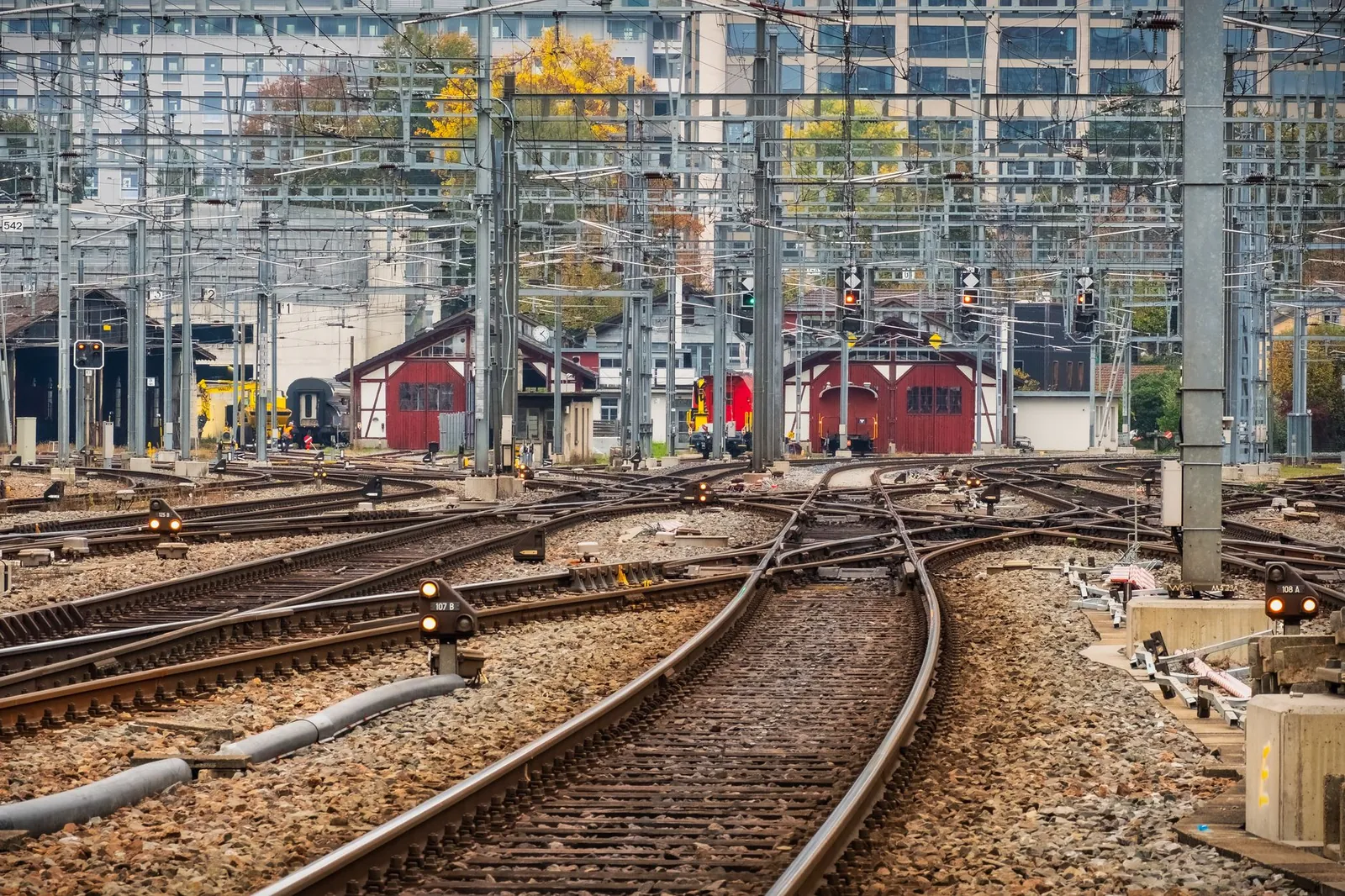 View of multiple railway tracks with signals and buildings in an urban setting during daytime. Stock photo illustrating GPT Infraprojects' earning call story.