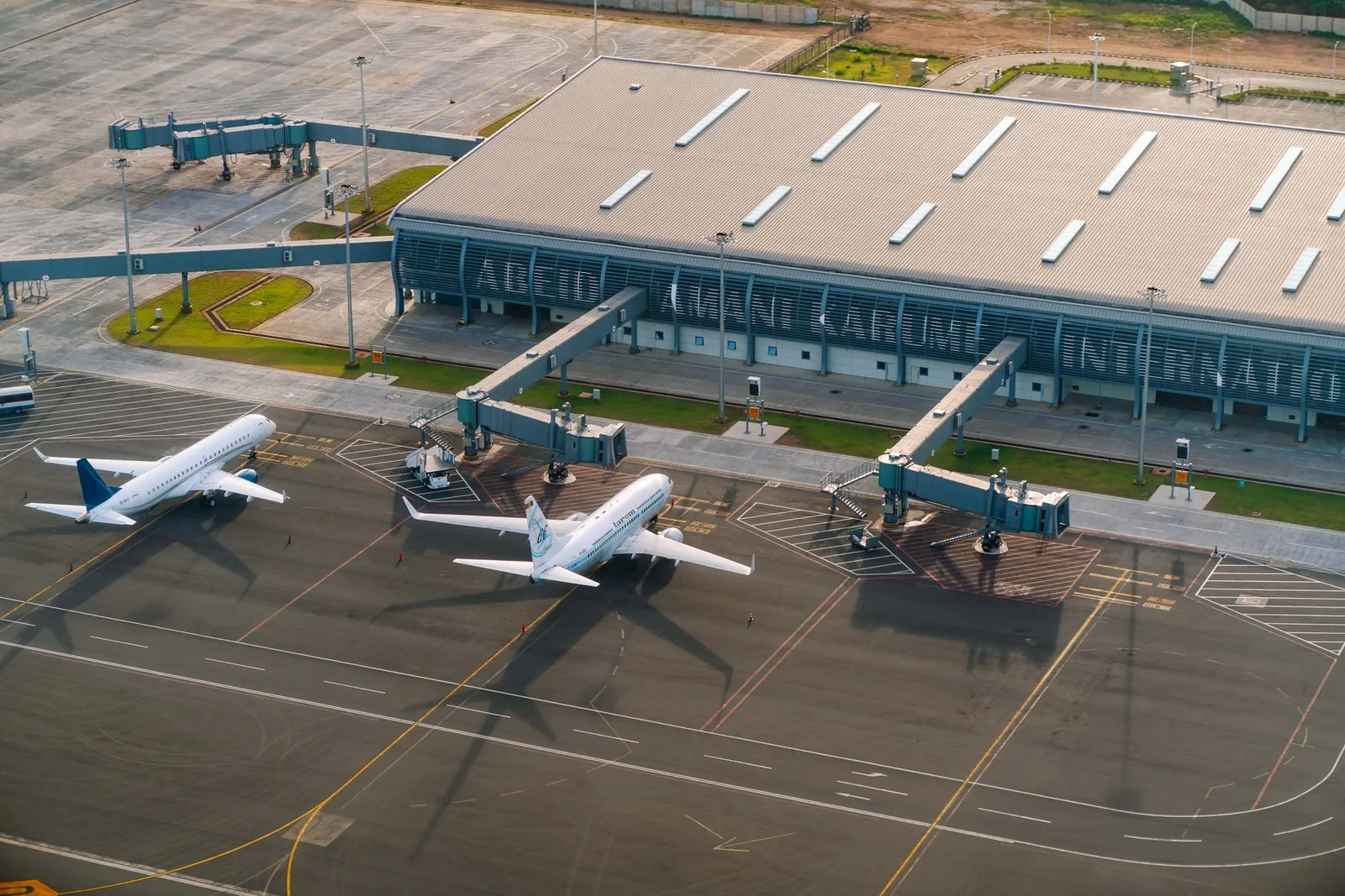 Aerial view of Abeid Amani Karume International Airport in Zanzibar, showing parked airplanes and terminal. Stock photo illustrating Adani Enterprises' fund raise story.