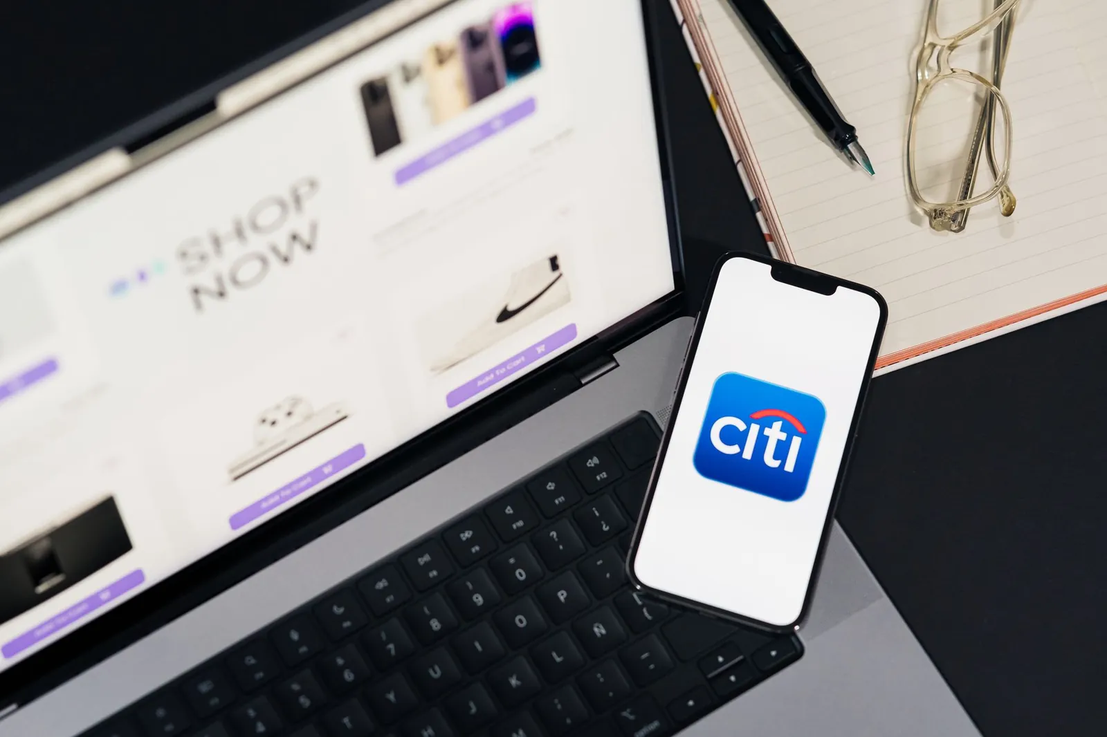 Laptop and smartphone showcasing online shopping and Citi mobile banking app. Stock photo illustrating Karnataka Bank's product launched story.