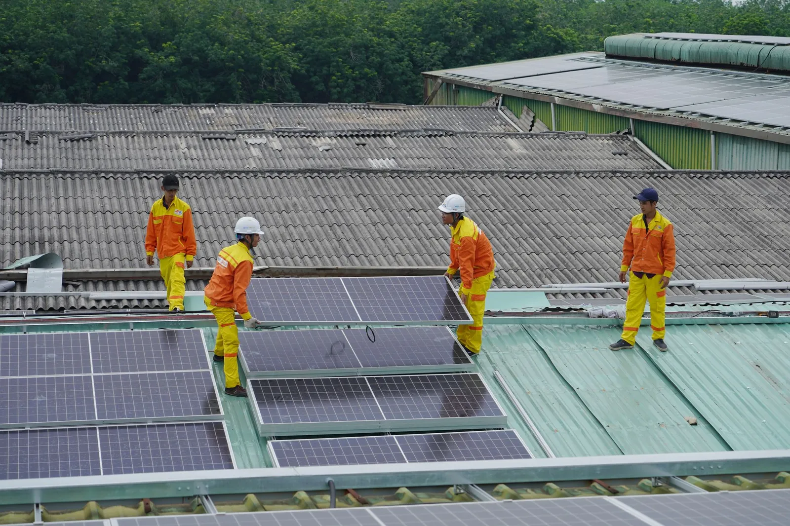 Workers installing solar panels on a roof for sustainable energy solutions. Stock photo illustrating GRE Renew Enertech's new order story.
