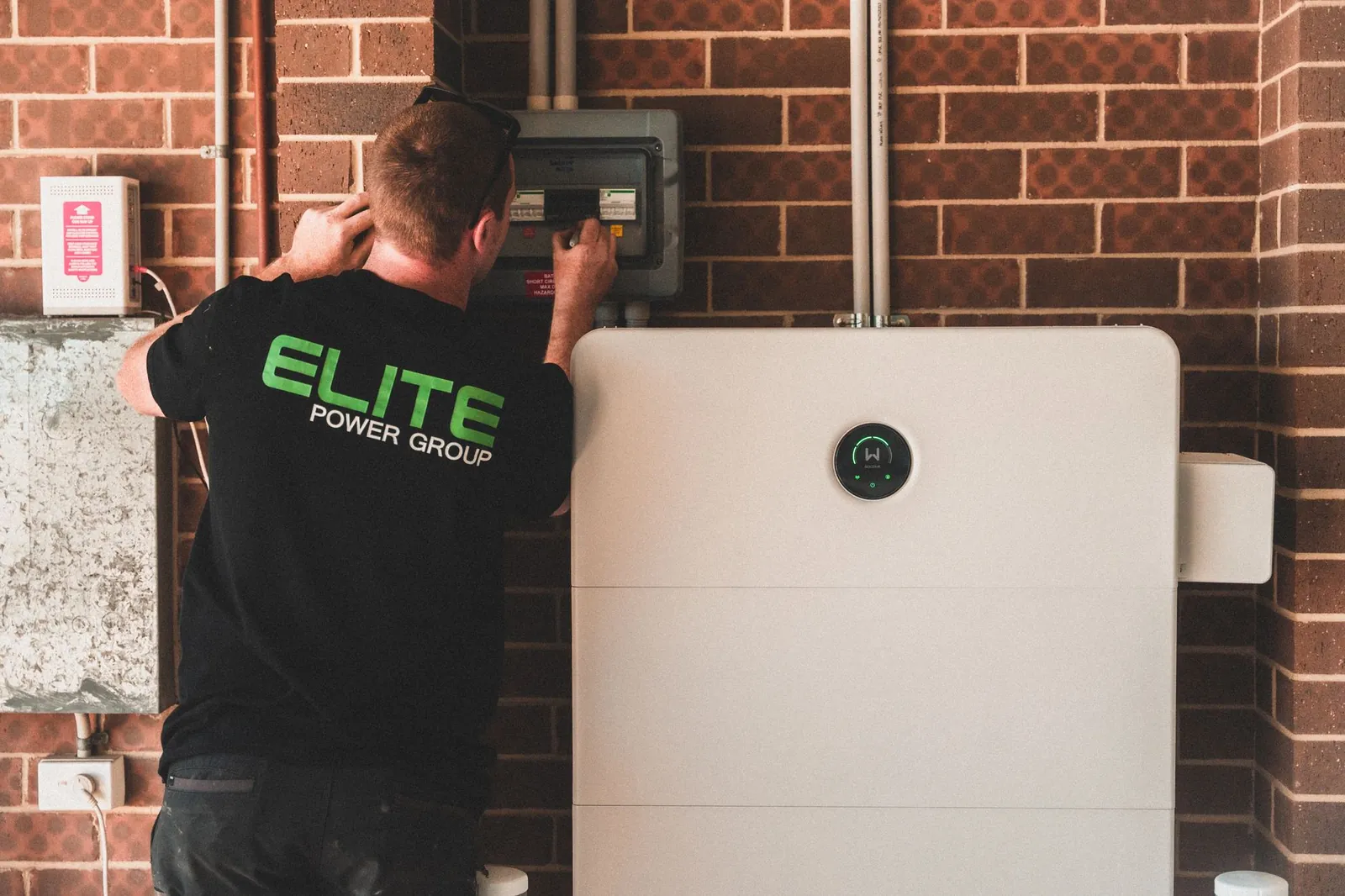 Electrician installing a home energy battery storage unit. Renewable and sustainable energy solution for residential use. Stock photo illustrating Pace Digitek's new order story.