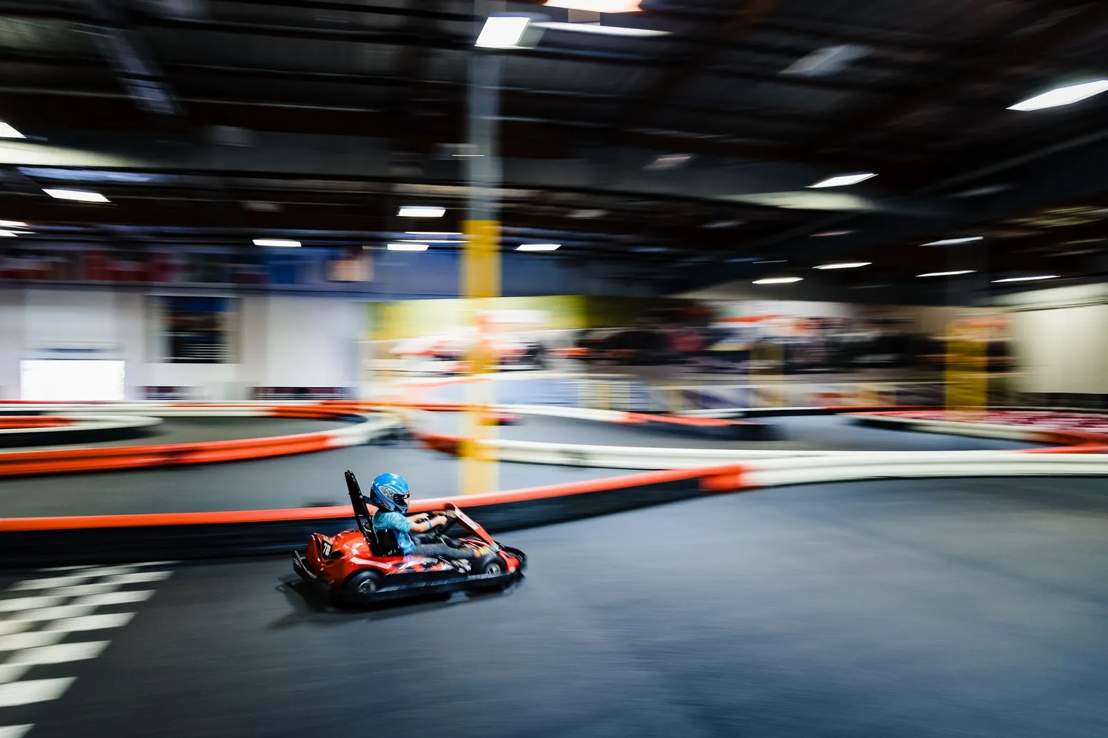 Blurred motion of a go-kart racer speeding on an indoor track during a thrilling race. Stock photo illustrating Complete Sports and Management India's new order story.