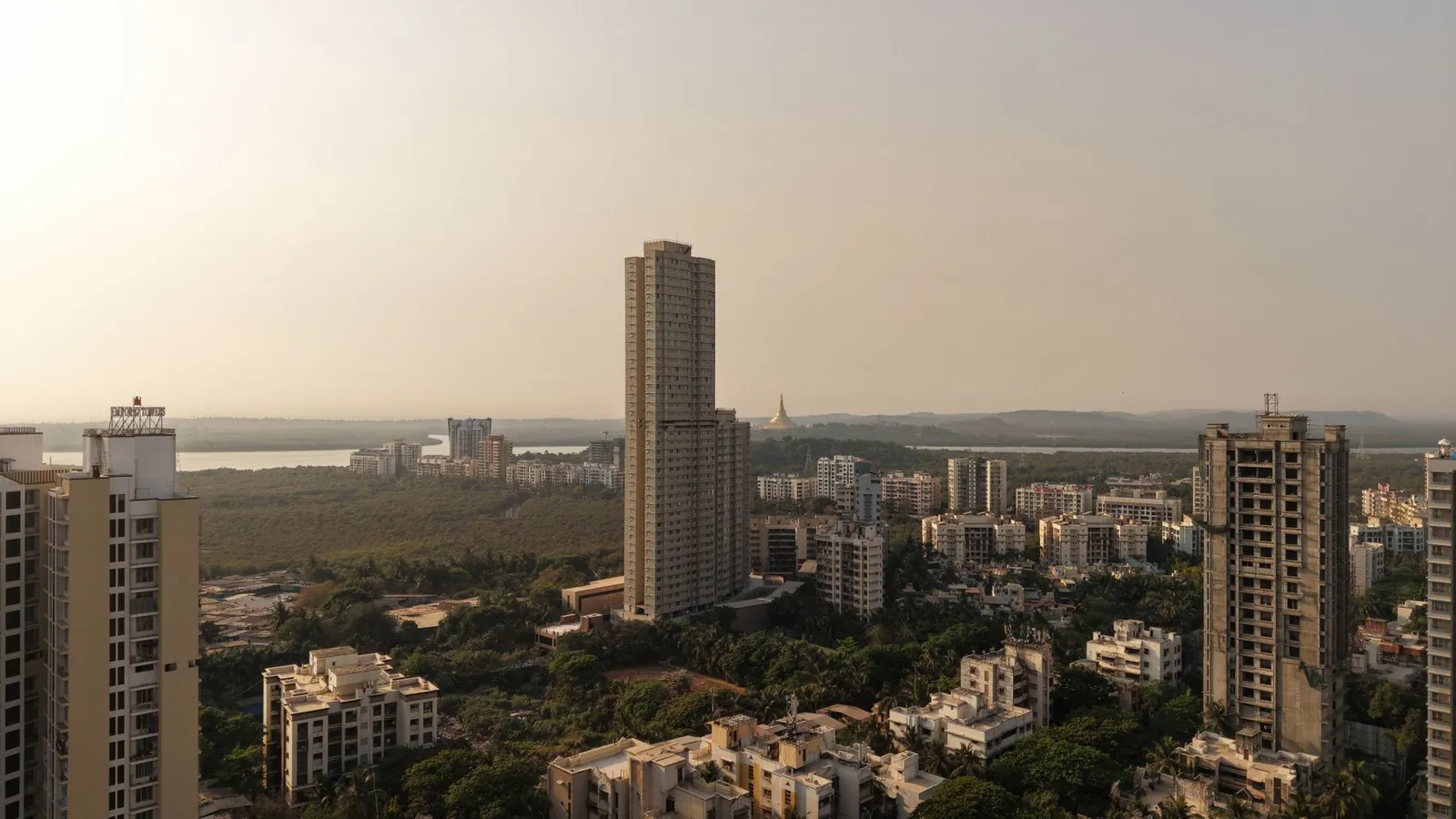 Aerial view of Mumbai skyline with tall buildings and green areas during the day. Stock photo illustrating HDFC Bank's regulatory approval story.
