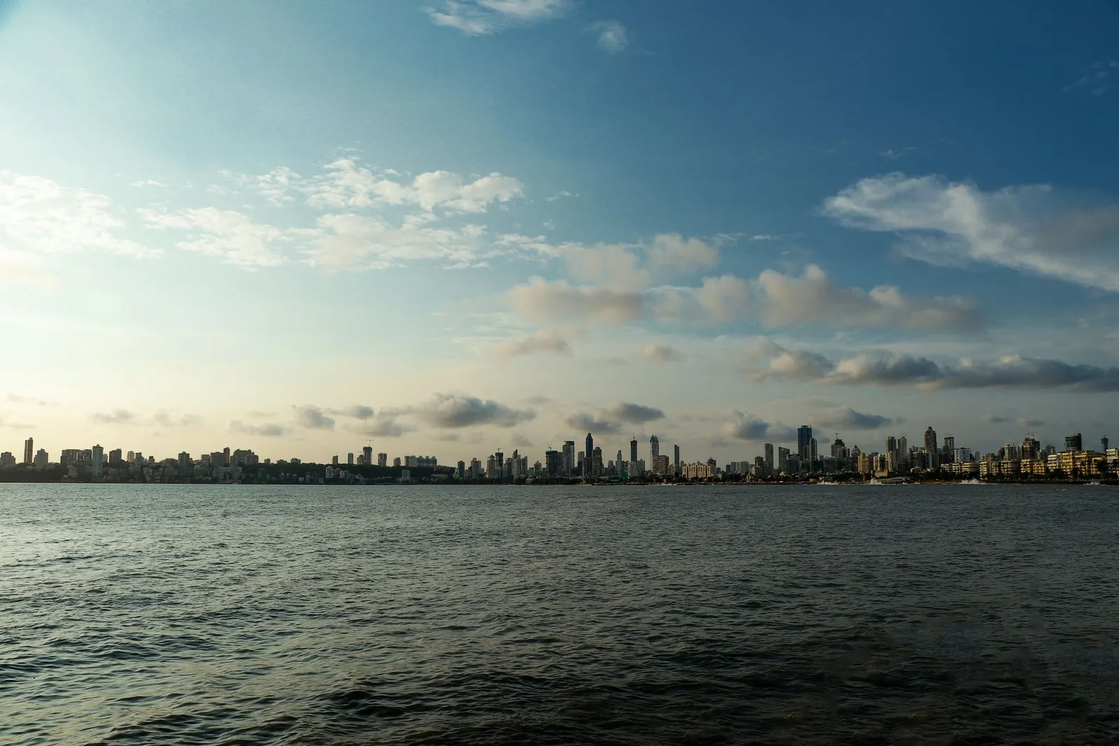 Panoramic view of Mumbai skyline with calm sea and cloudy sky in daylight. Stock photo illustrating Gaja Alternative Asset Management's regulatory approval story.