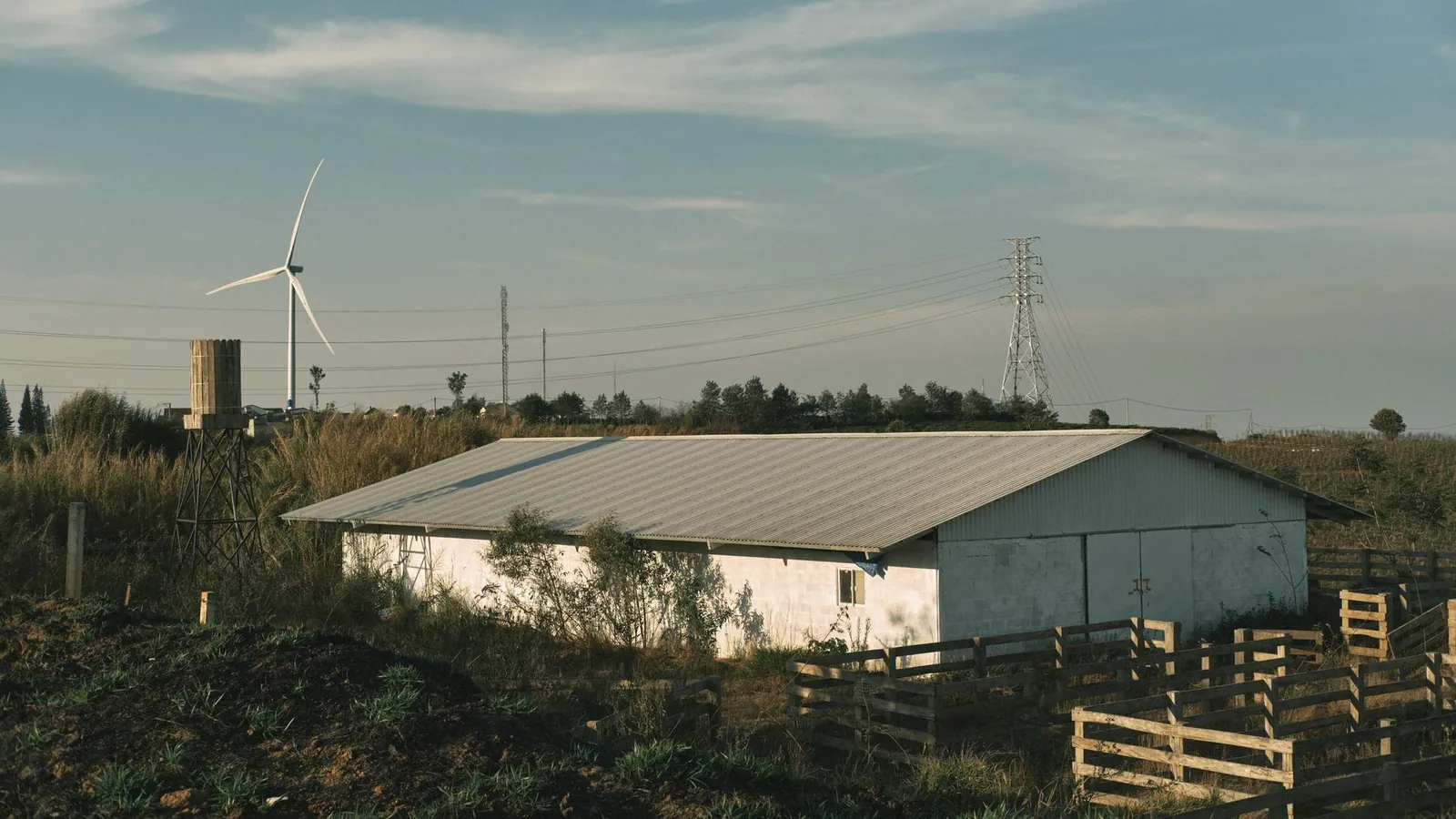 Scenic rural farm landscape with barn and wind turbine. Stock photo illustrating Clean Max Enviro Energy Solutions' fund raise story.