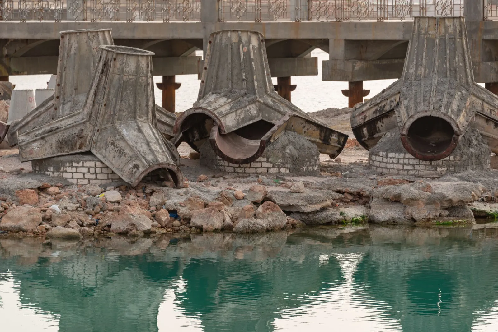 Concrete bridge construction site with rusty components and water reflection. Stock photo illustrating VA Tech Wabag's new order story.