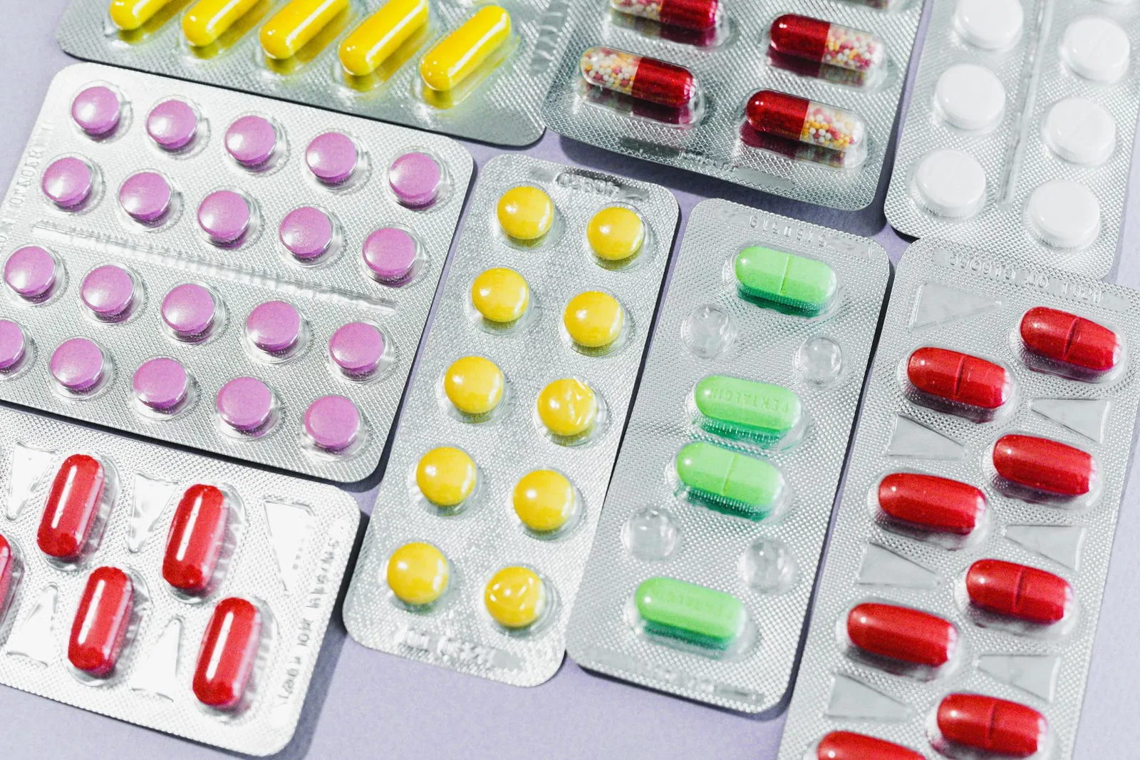 A variety of colorful pills and tablets in blister packs, representing diverse medication types. Stock photo illustrating Mankind Pharma's financial results story.